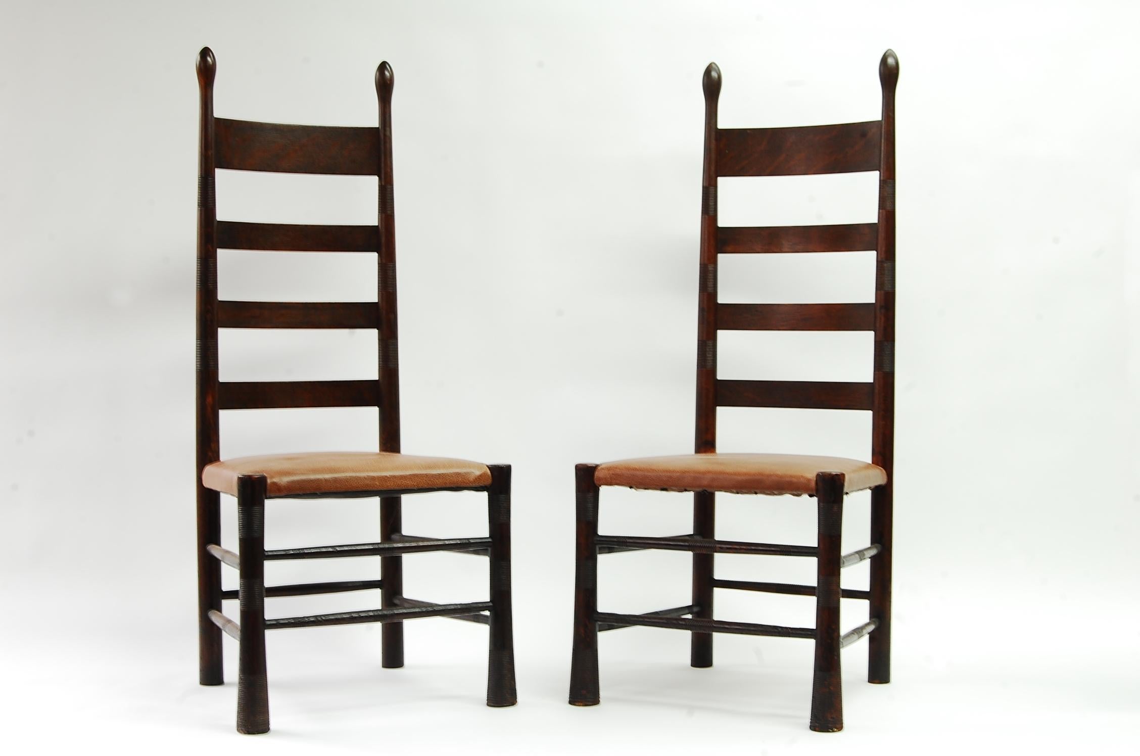 Pair of English Aesthetic Movement chairs in oak, circa 1890-1910, attributed to E.G. Punnet & William Birch. Most likely retailed by Liberty and Company, London. Some might consider these transitional Arts & Crafts. Currently upholstered in