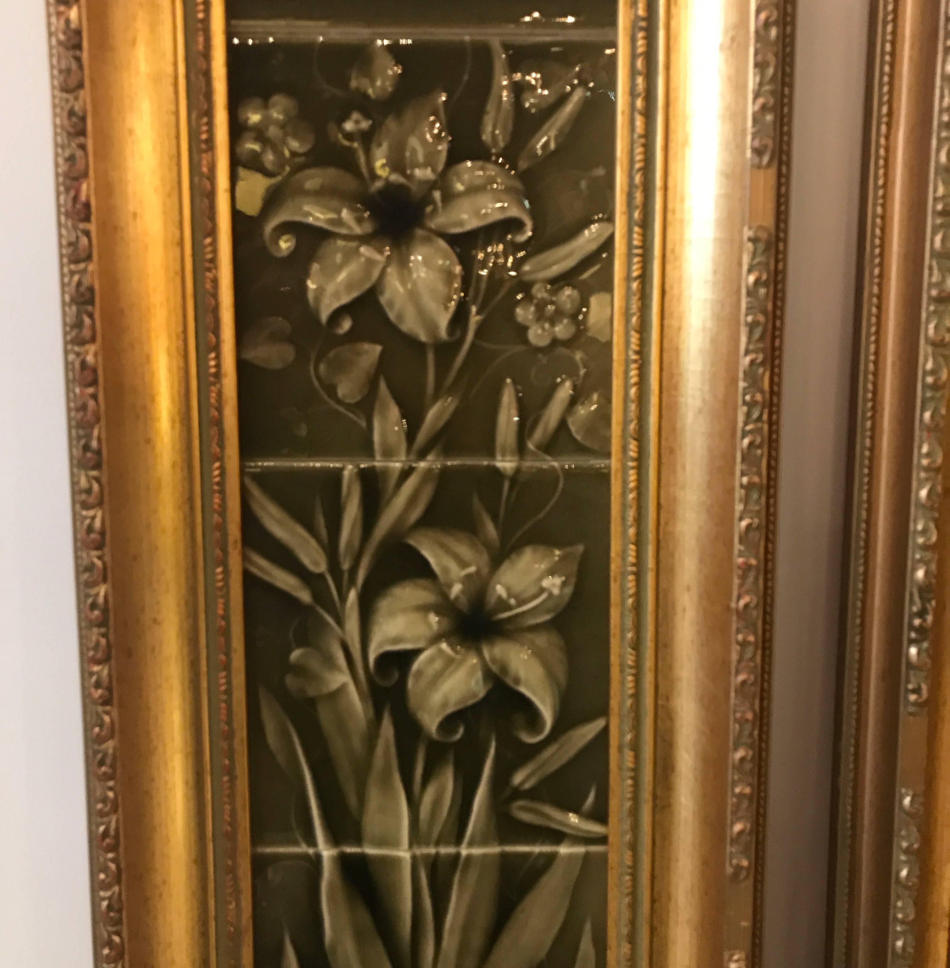 A pair of Aesthetic Movement set of framed tiles. Each framed set of four is a complete set of potted lilies in a rich sage green background with three dimensional tiles to form the subject. The giltwood frames are later showing wear and
