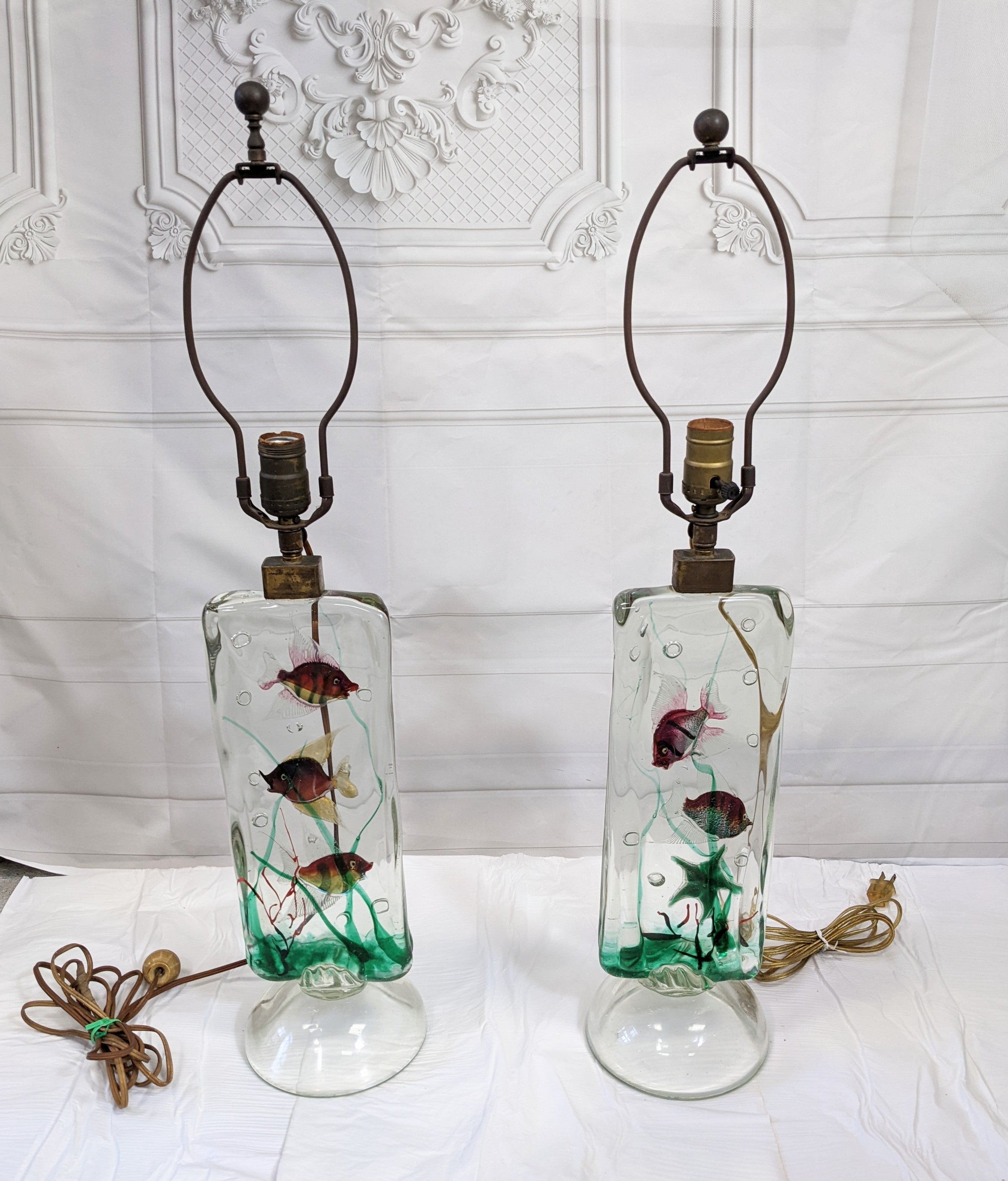 Exceptional and rare pair of Alfredo Barbini for Cenedese Aquarium lamps with original linen shades. One lamp has 3 fish in seascape and the other has 2 fish and a starfish. Original wiring. 1950's Italy.
Total Assembled Height with shades 29.5
