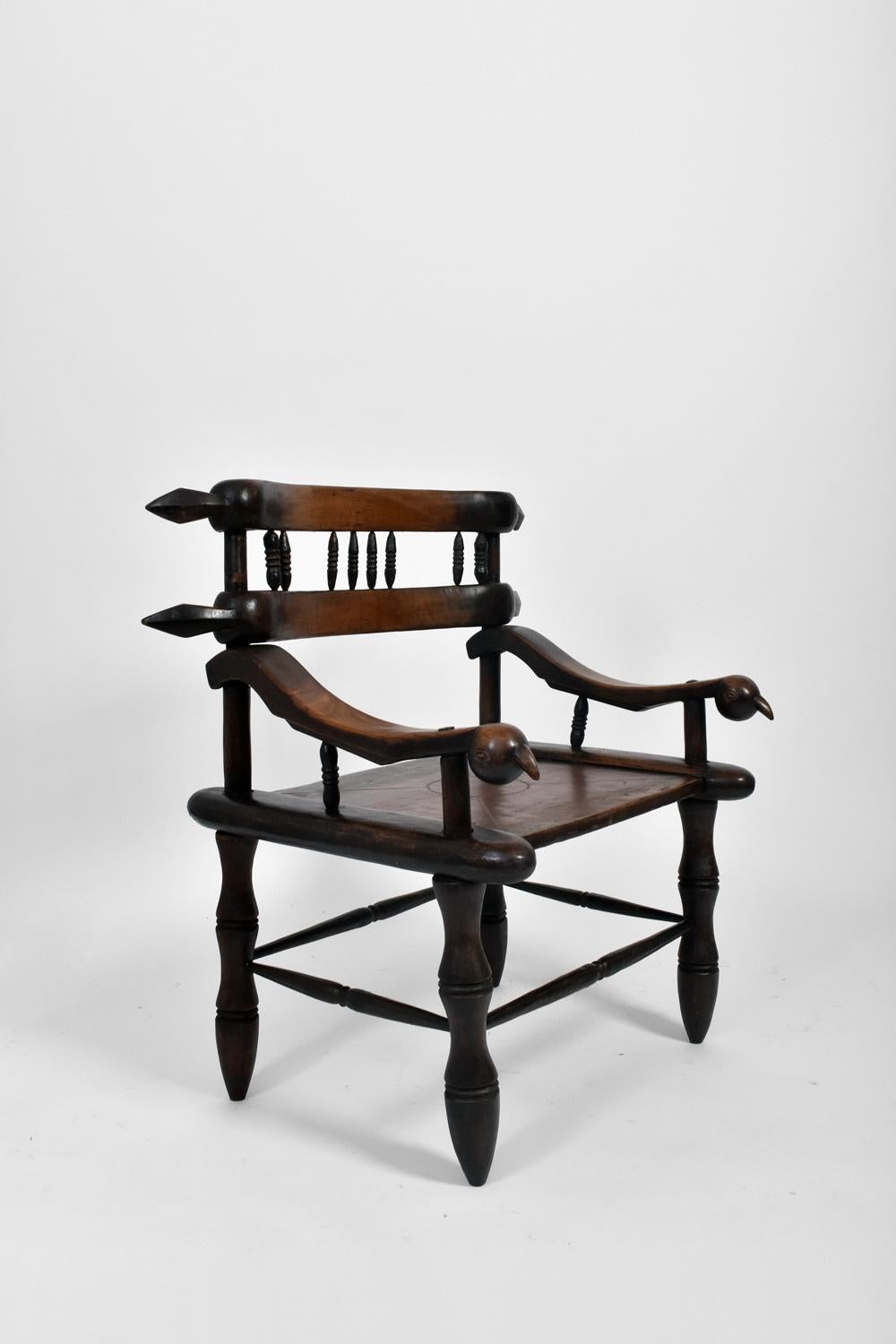 Large pair of ceremonial armchairs in carved wood with zoomorphic armrests in the shape of birds, the backrest with spindle bars, round legs. African work, 20th c.