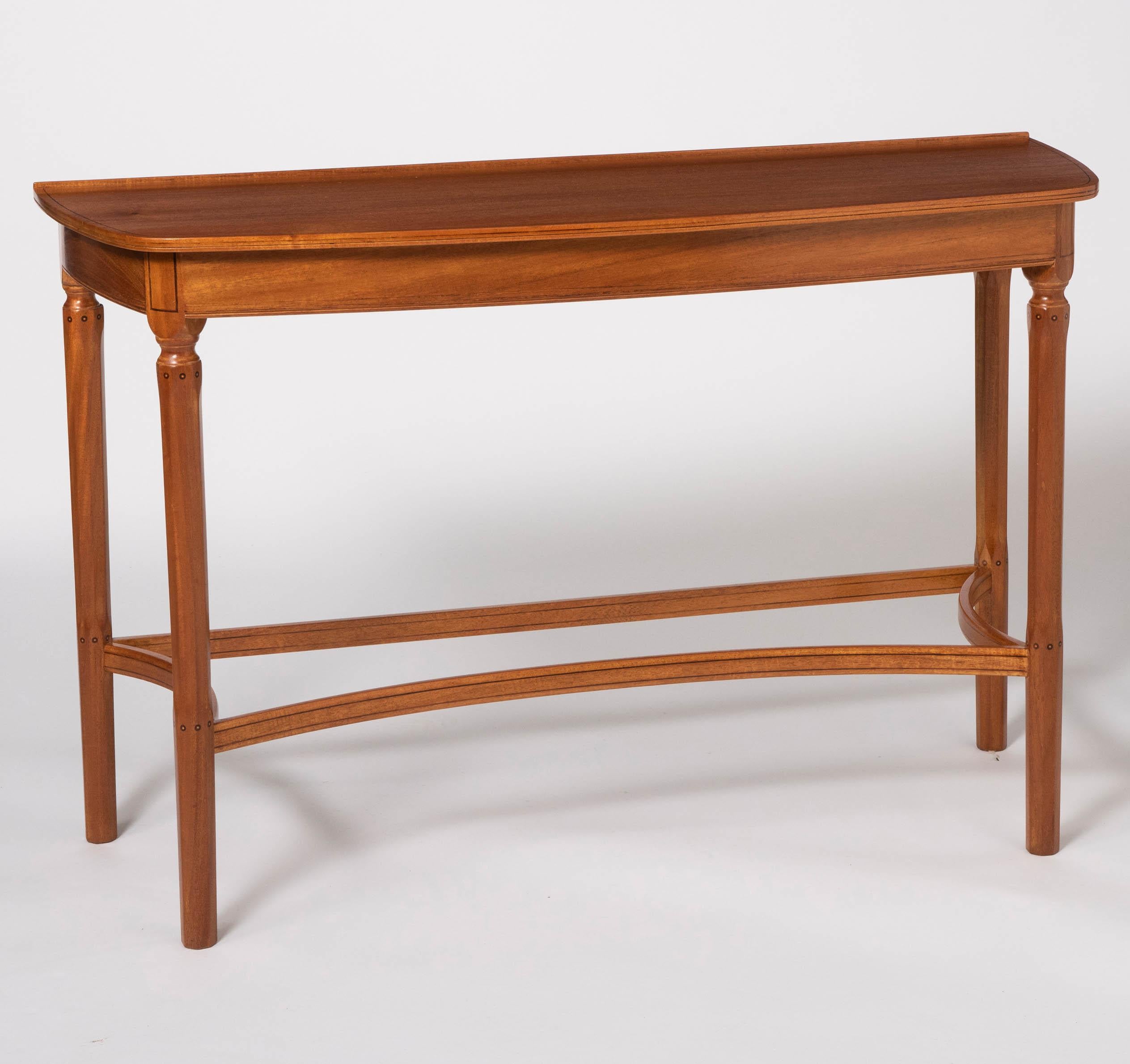 A pair of side tables by Edward Barnsley
African mahogany with Holly stringing.
The “D” shaped tops on octagonal turned legs inlaid with small marquetry roundels joined by inswept stretchers.
The tables were made for the anti-room and designed to