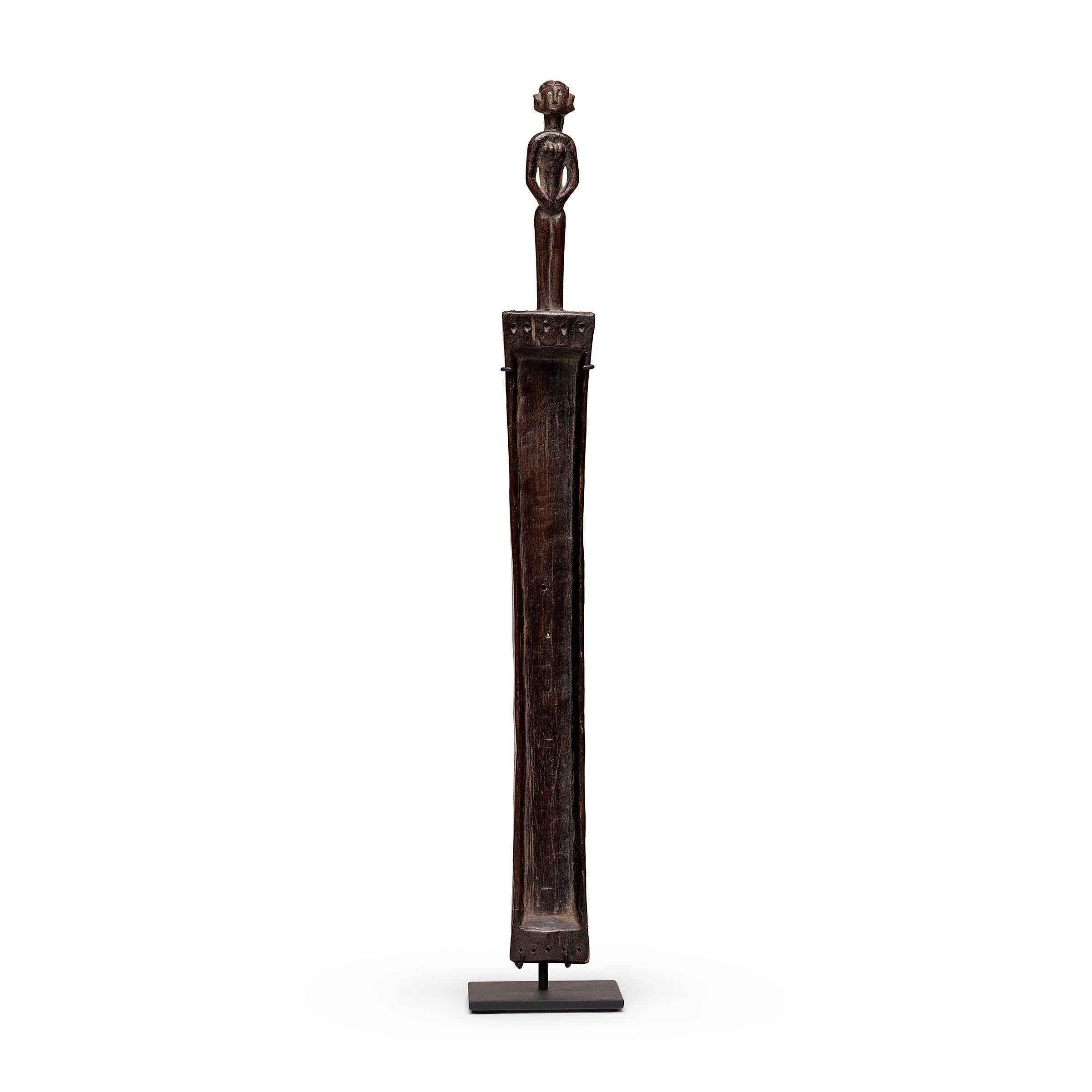 Queste sculture in legno sono strumenti a corda noti come ligombo, una forma di cetra a trogolo allungata attribuita al popolo Nyamwezi della Tanzania e dell'Africa orientale. Originariamente fissato a un risonatore fatto di zucca essiccata, il