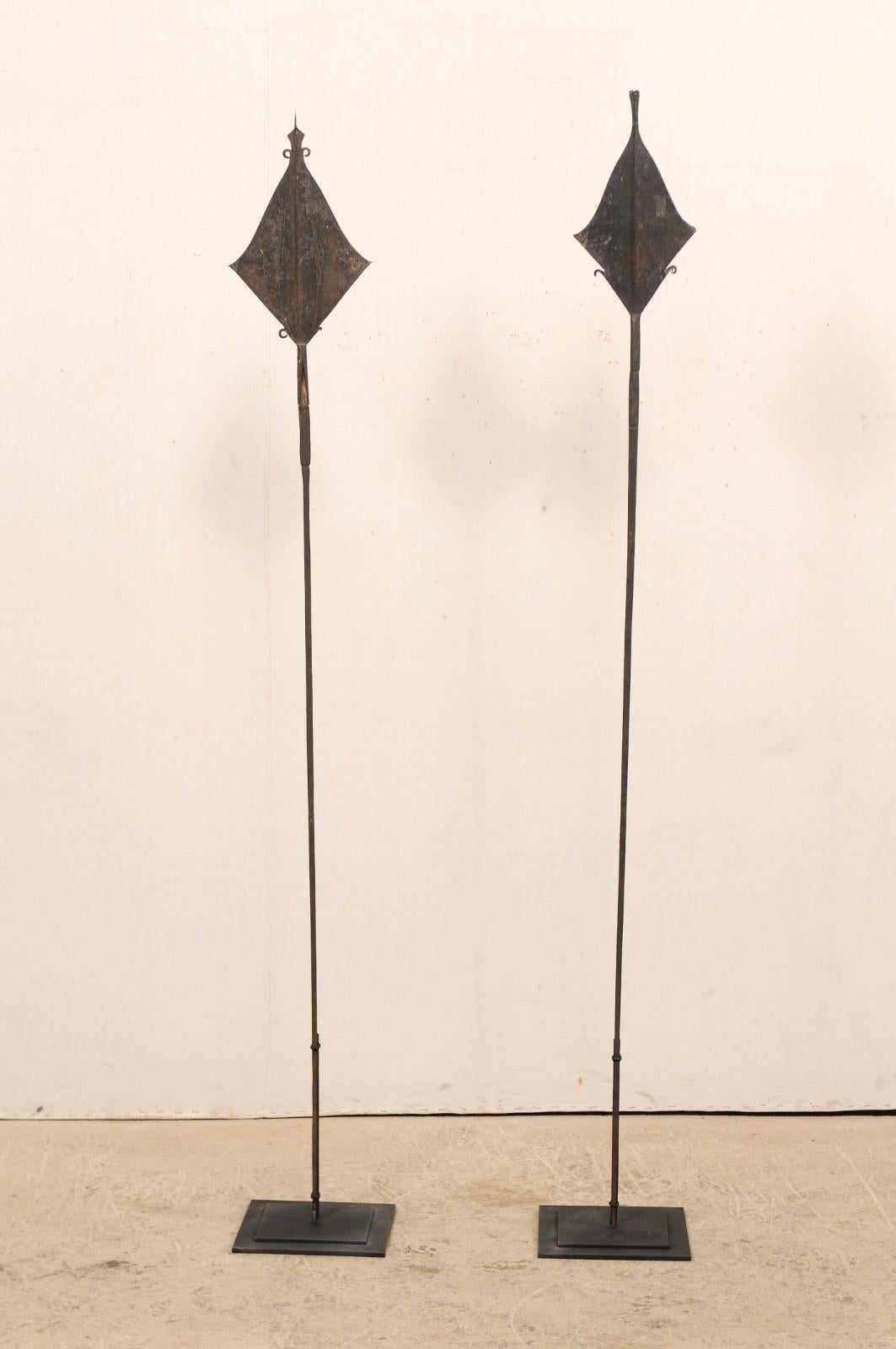This is a pair of vintage African spear currencies from the Mbole peoples, Democratic Republic of Congo which are nicely presented upon custom metal stands. These African currencies take their name from their spear-shaped tip design, though due to