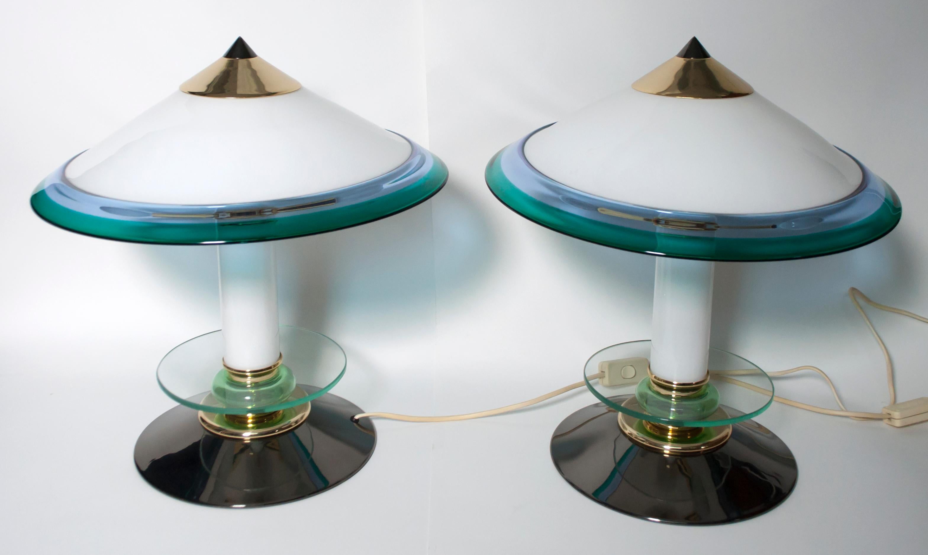 This pair of Murano glass lamps, produced in the 1980s, have a gunmetal metal base and brass parts. They were designed in the style of Ettore Sottsass, in the 1980s.