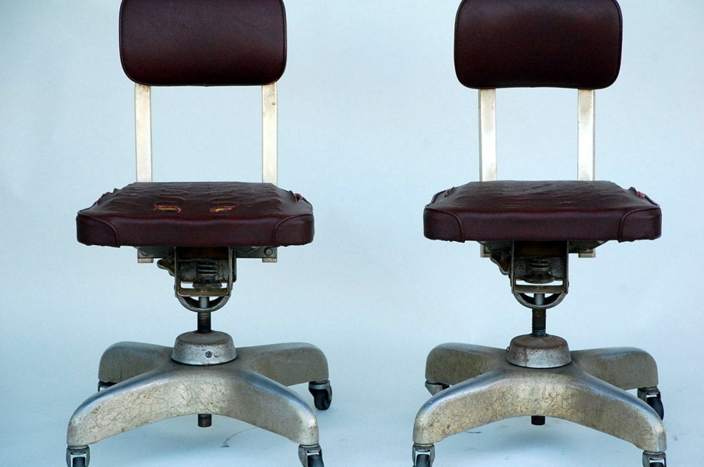 Pair of aged industrial office swivel chairs.