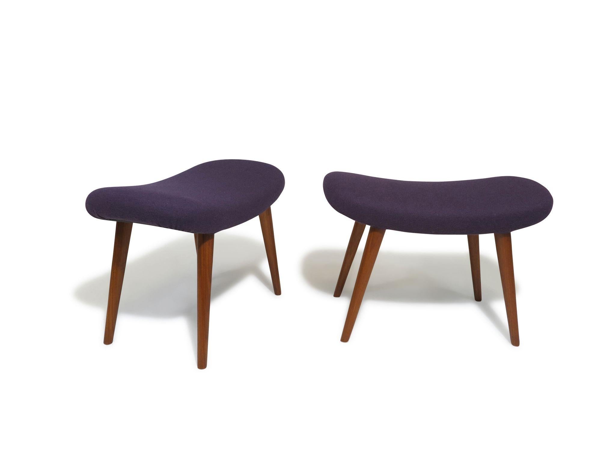 Mid-century ottomans designed by Aksel Bender Madsen in 1955, Denmark. Crafted with curved oval seats and raised on tapered teak legs, these ottomans have been newly upholstered in purple wool. They can be used as ottomans or stools. Fully restored,
