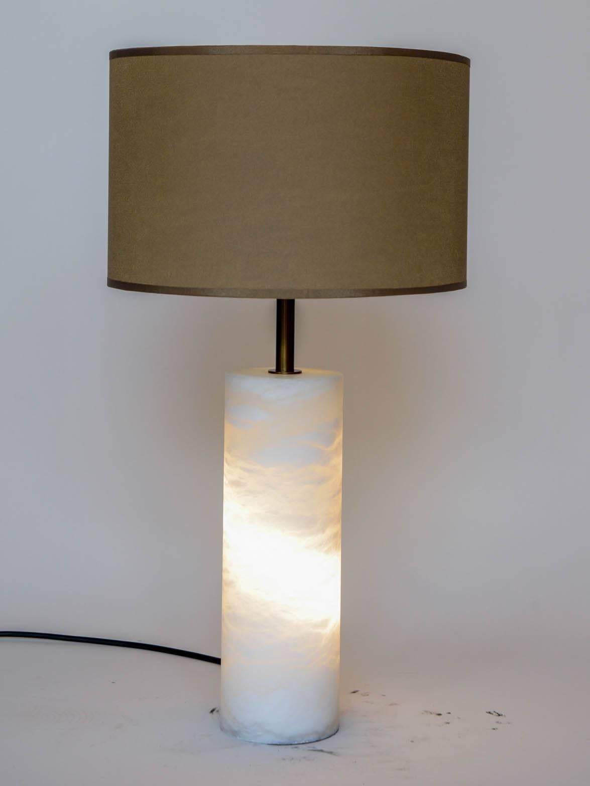 New design by Glustin Luminaires, pair of table lamps made of a hollow alabaster cylinder and brass setting. Two different set of lights, one in the cylinder and one bulb at the top that can be turn on separately.