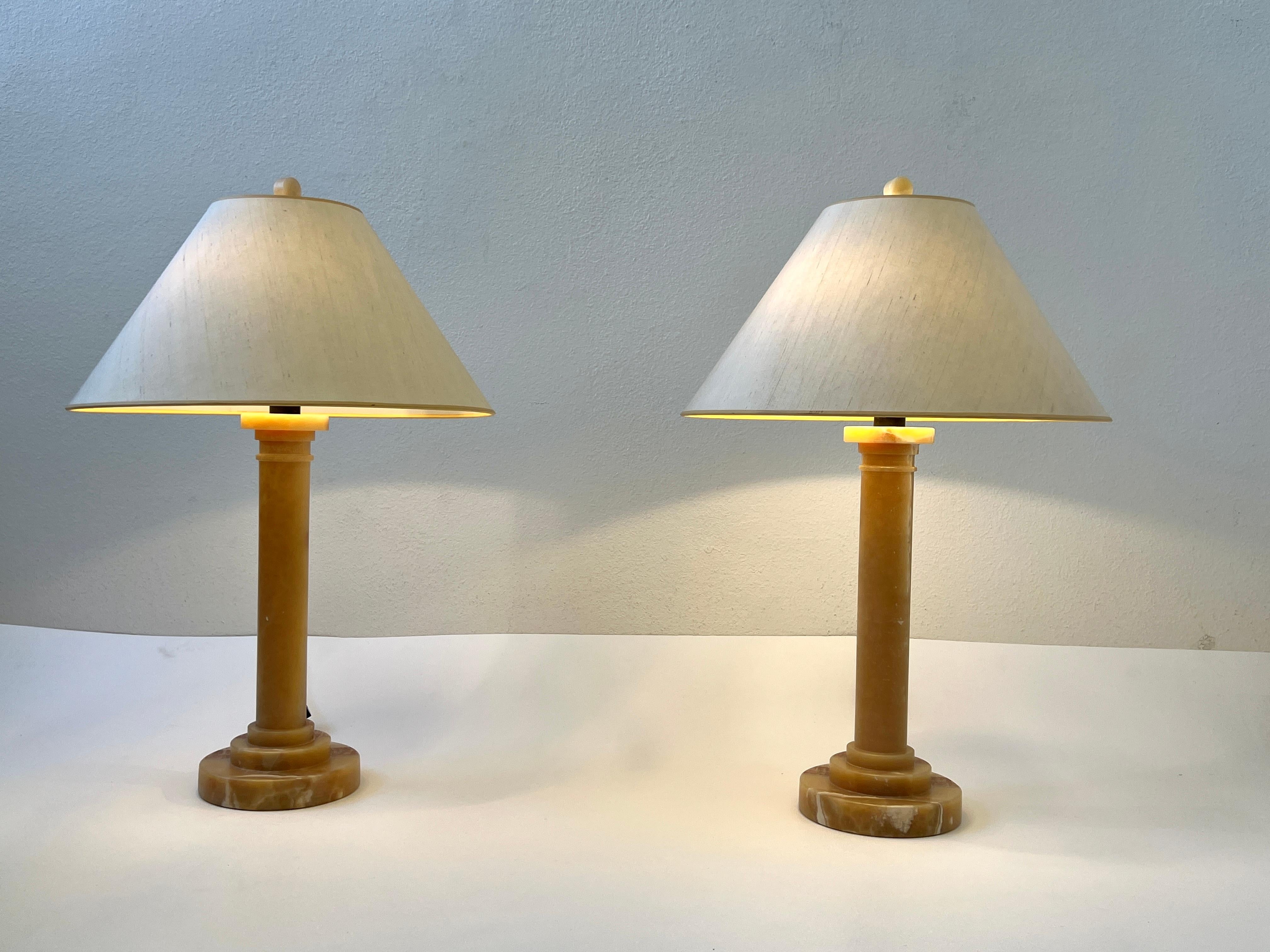 Pair of 1990’s alabaster and aged bronze table lamps by Donghia.
Newly rewired, the lamps have original off white silk lamp shades. One of the lamps retains the Donghia paper label. 

Measurements: 20.25” Diameter, 29.25” High, 8” Diameter base. The