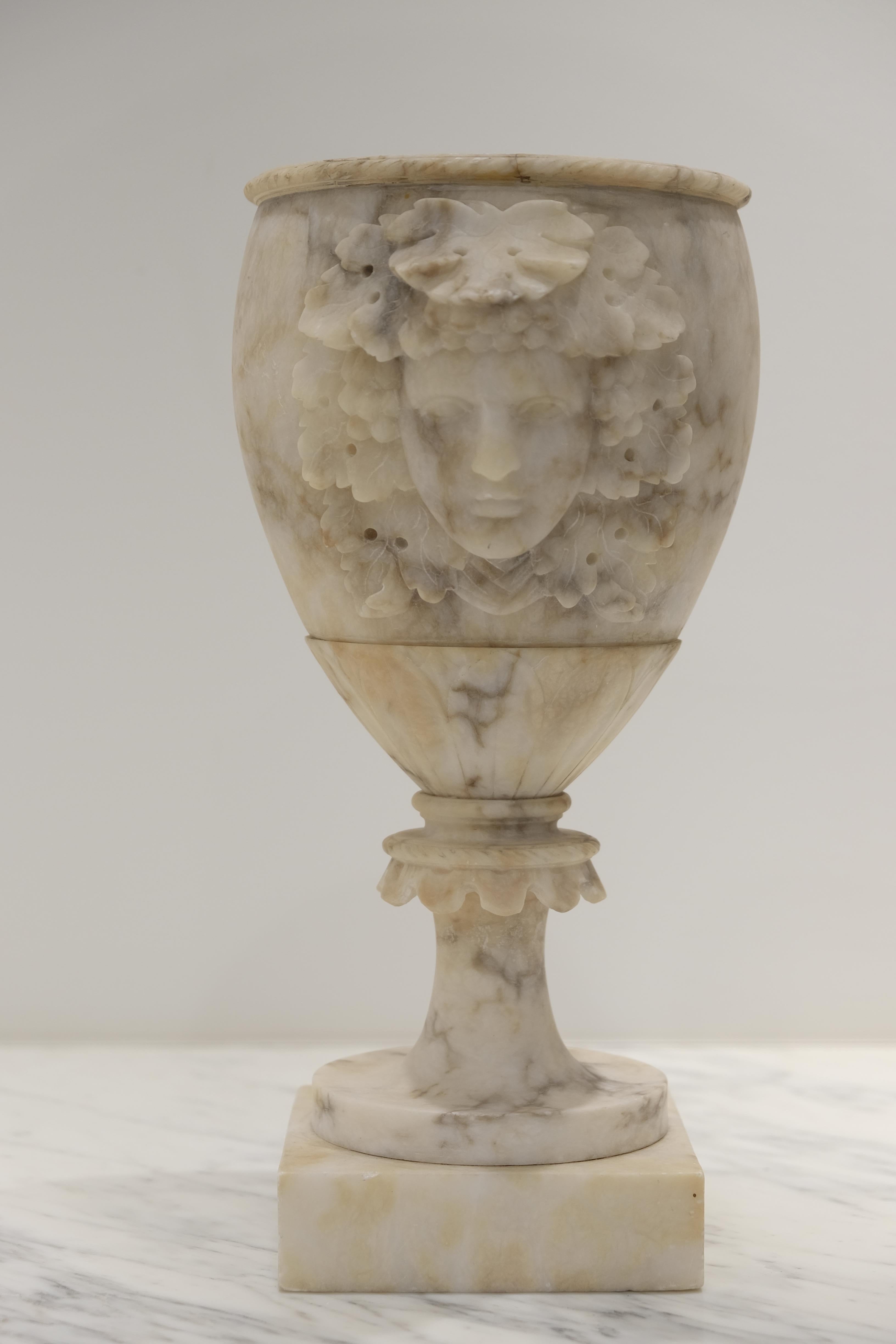 Grand Tour carved alabaster vases in goblet form with Dionysus heads. Elegant and decorative with a gorgeous patina.
      