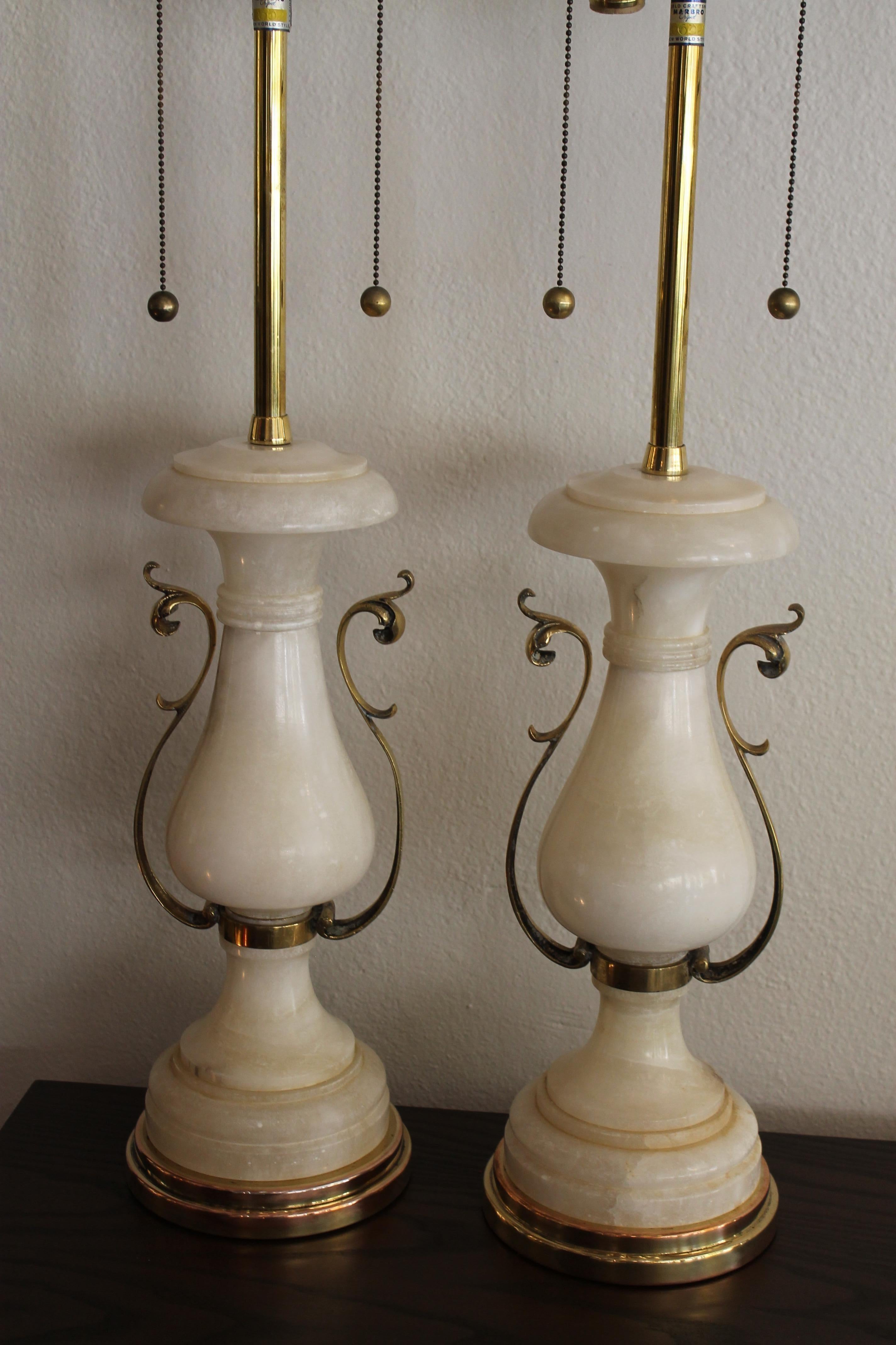 Pair of alabaster lamps by The Marbro Lamp Company. Each lamp measures: 7.5” diameter (base), 38.25” high from base to the top of finial. Alabaster portions are 17.5” high. Lamps have been professionally rewired.
     