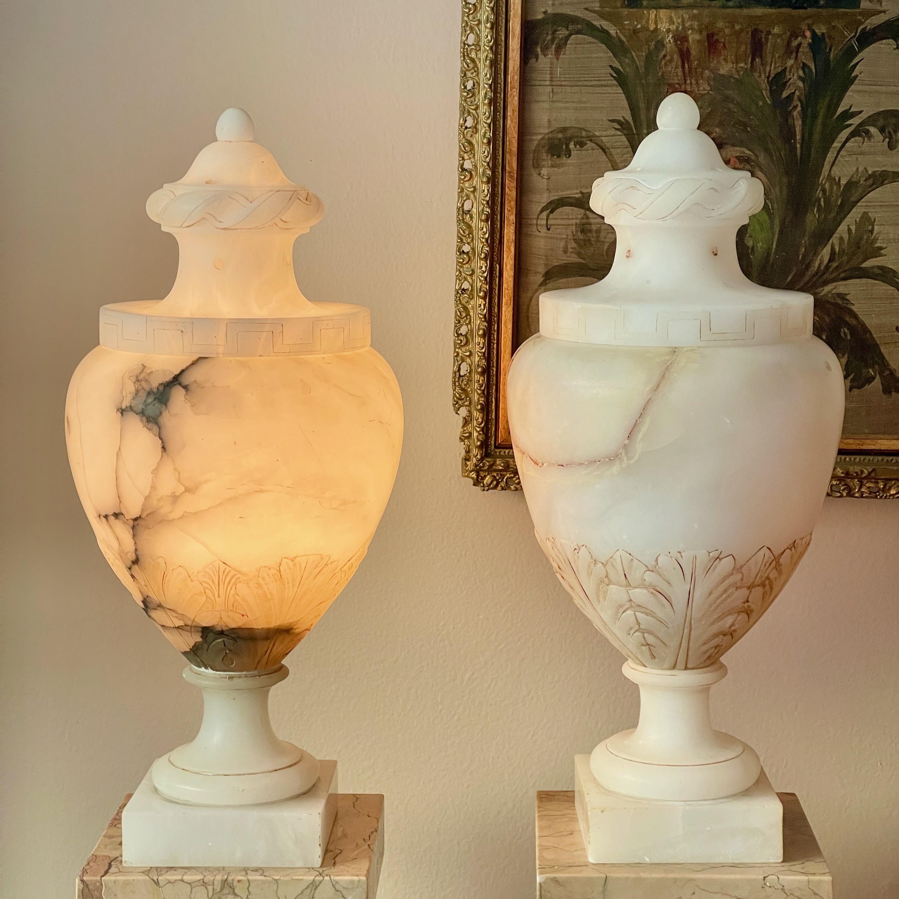 Pair of Italian alabaster lidded vase-form urns with internal illumination, wheel turned foot and base and delicate carving of acanthus leaves on the lower side of urns and greek key motif to rim of lids.
These are an elegant classical form and