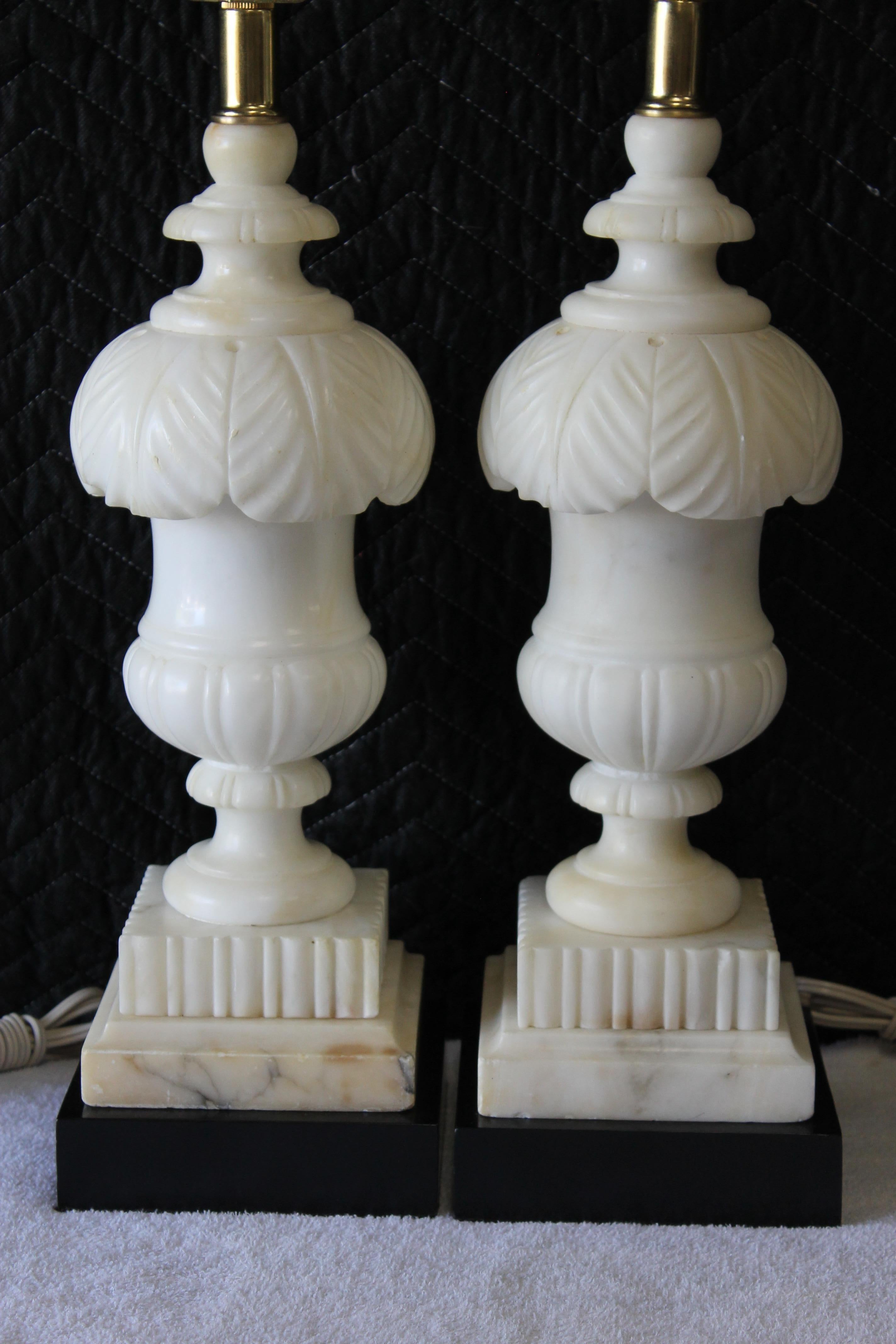 A pair of 1940s carved alabaster table lamps with black painted wood bases. These measure 17