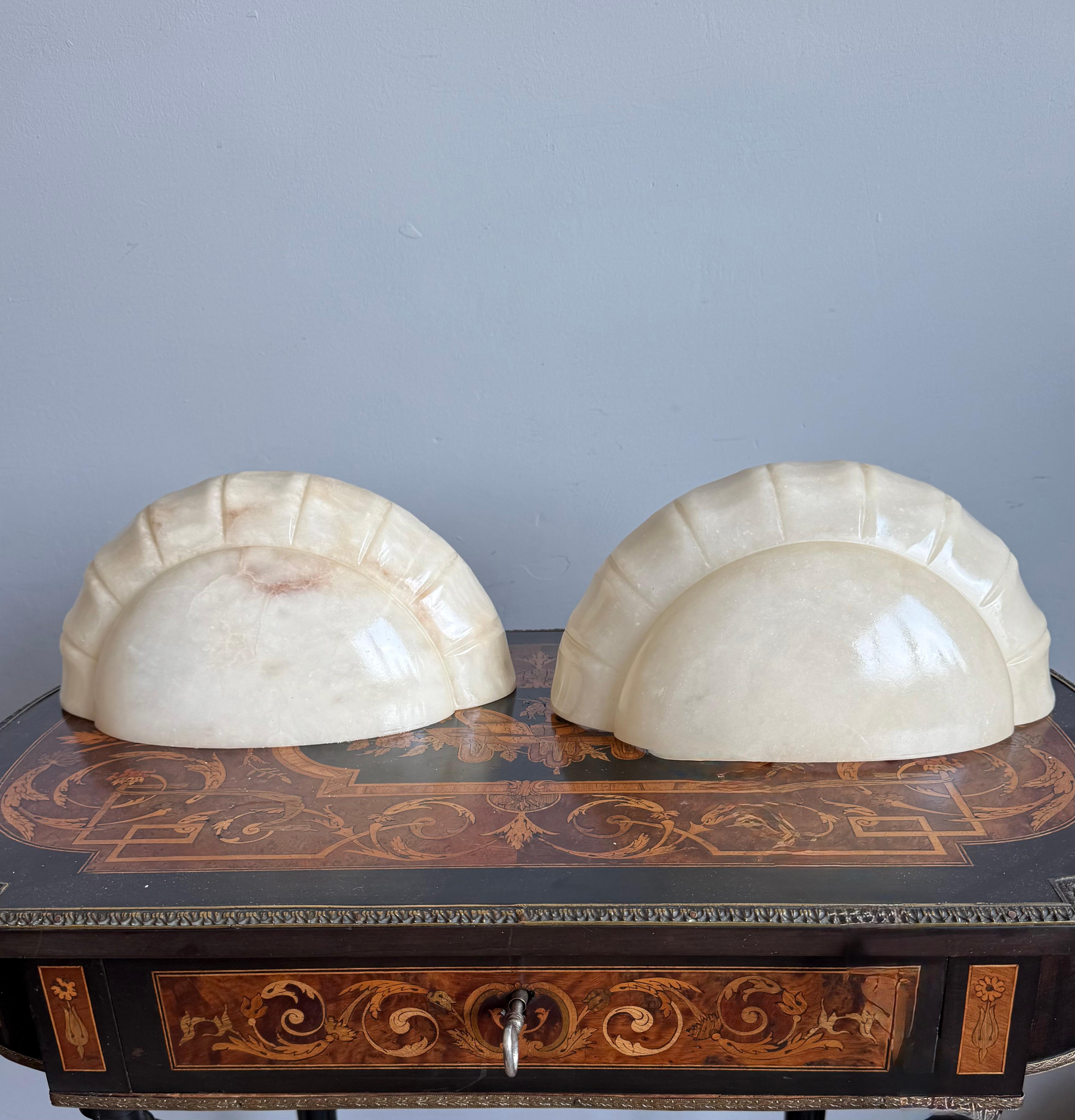Mid-Century Era Mint Pair of Art Deco Style White Alabaster Wall Sconces / Lights.

Bring timeless elegance and organic sophistication into your interior with this striking pair of Italian alabaster wall sconces from the 1970s. Sculpted in a refined
