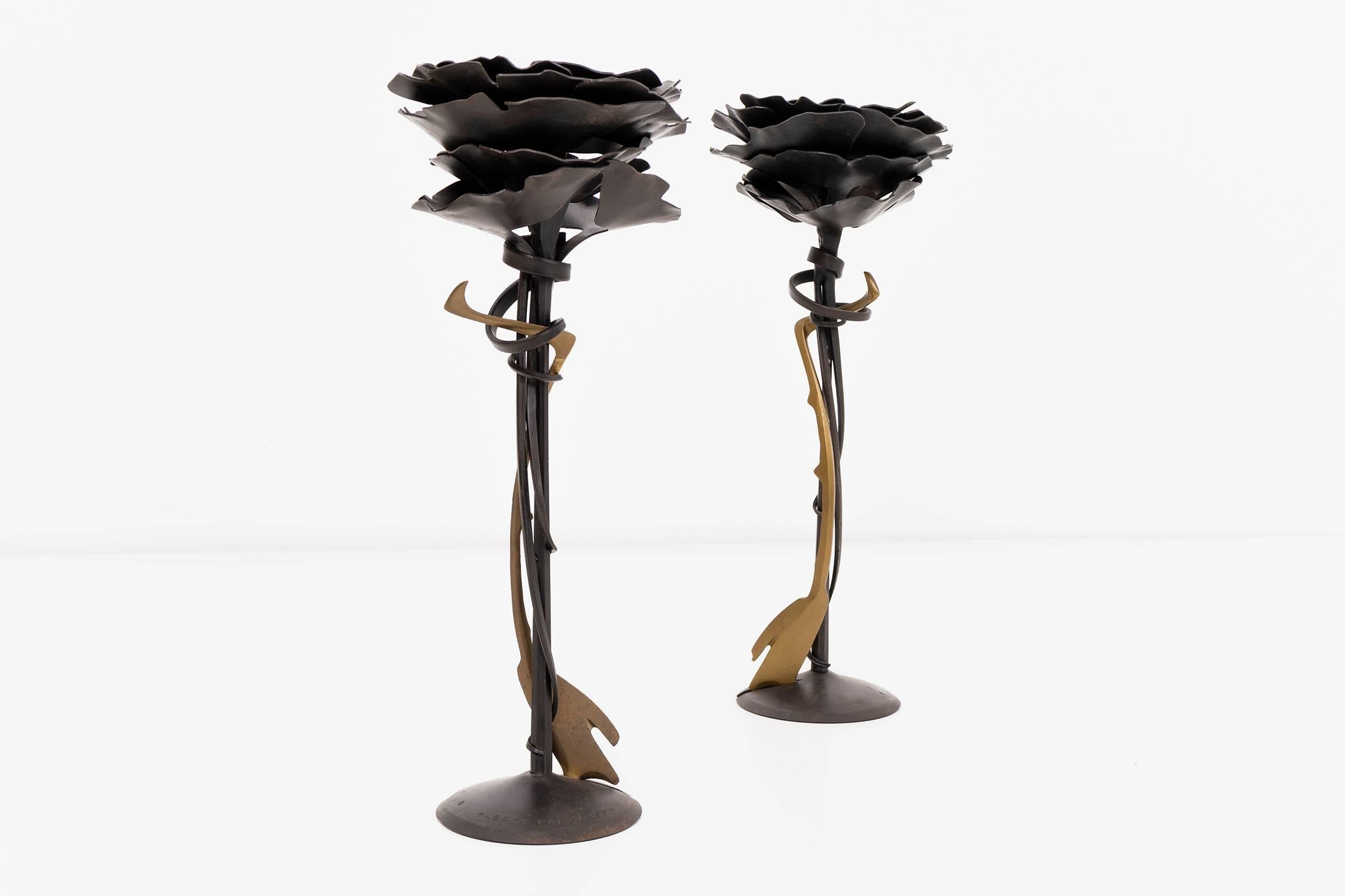 A pair of blossom candlesticks by Albert Paley Studio. Forged and blackened steel with brass accent. Signed and dated [Albert Paley 1994].

