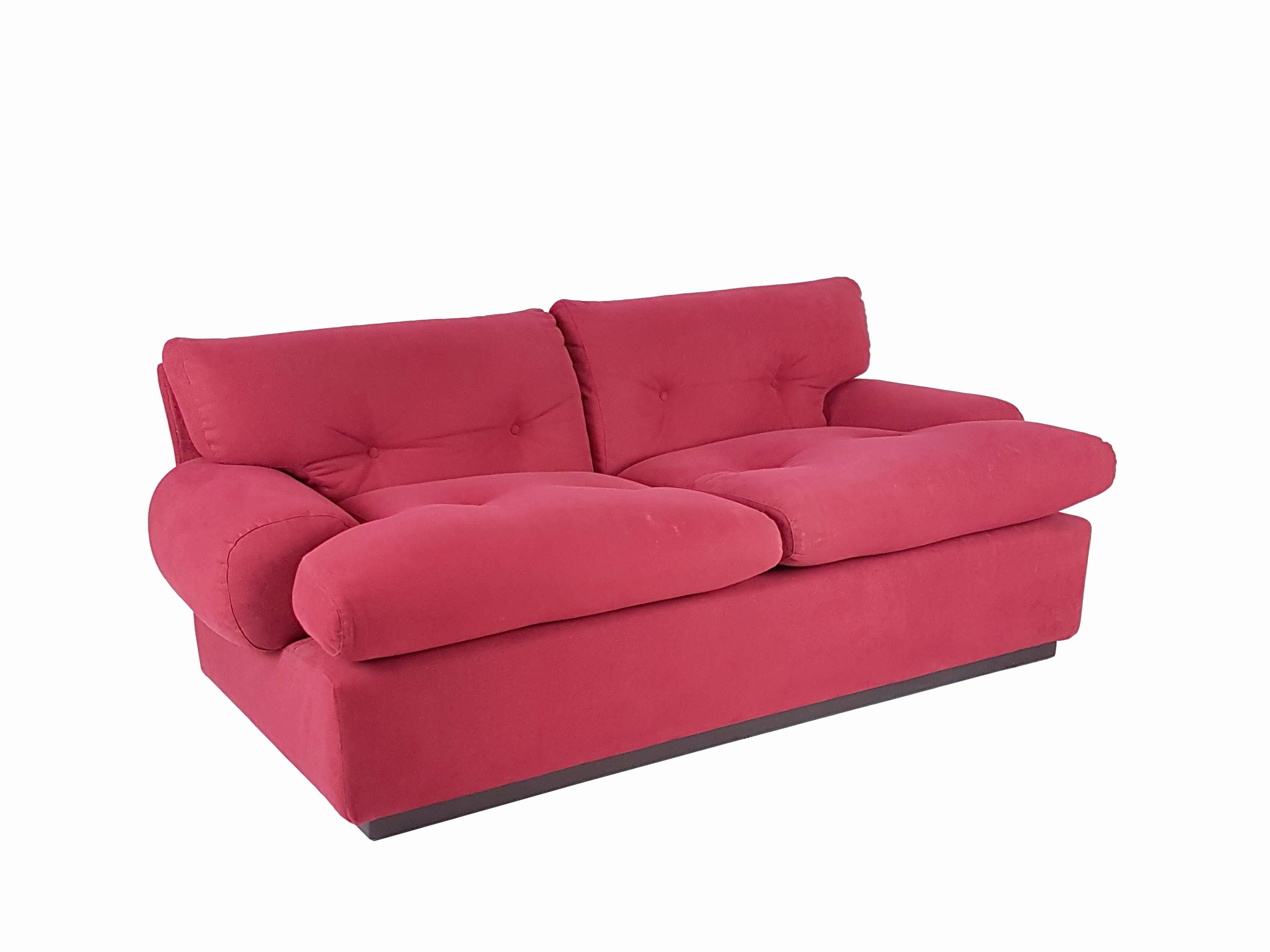 This pair of 2-seat sofa was designed and produced in Italy at the end of the 1960s. They have been originally upholstered with Alcantara synthetic fabric in a precious crimson color. They feature a wooden frame base and remain in very good