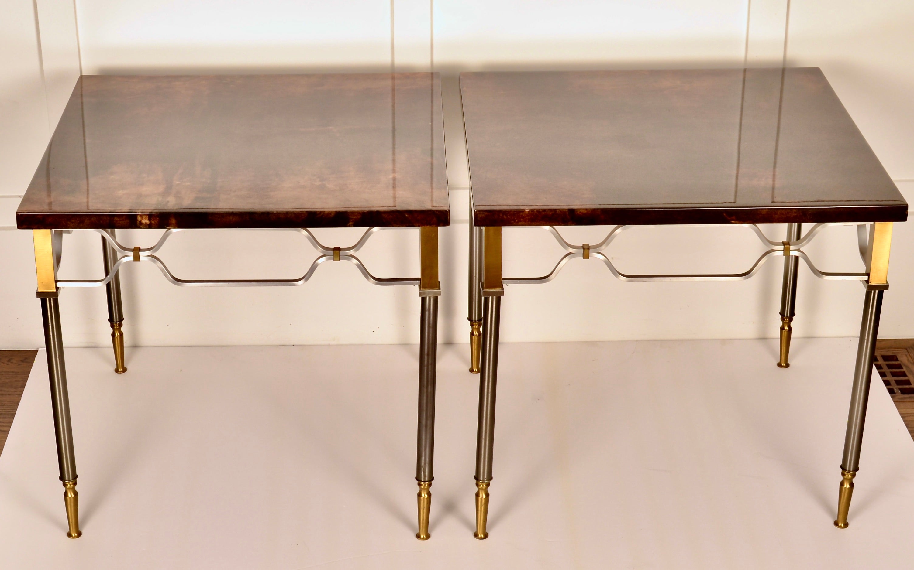 High style mixed metal bases on this pair of side tables by Aldo Tura. Beautifully patterned goat skin tops with super high gloss finish. Beautiful condition.