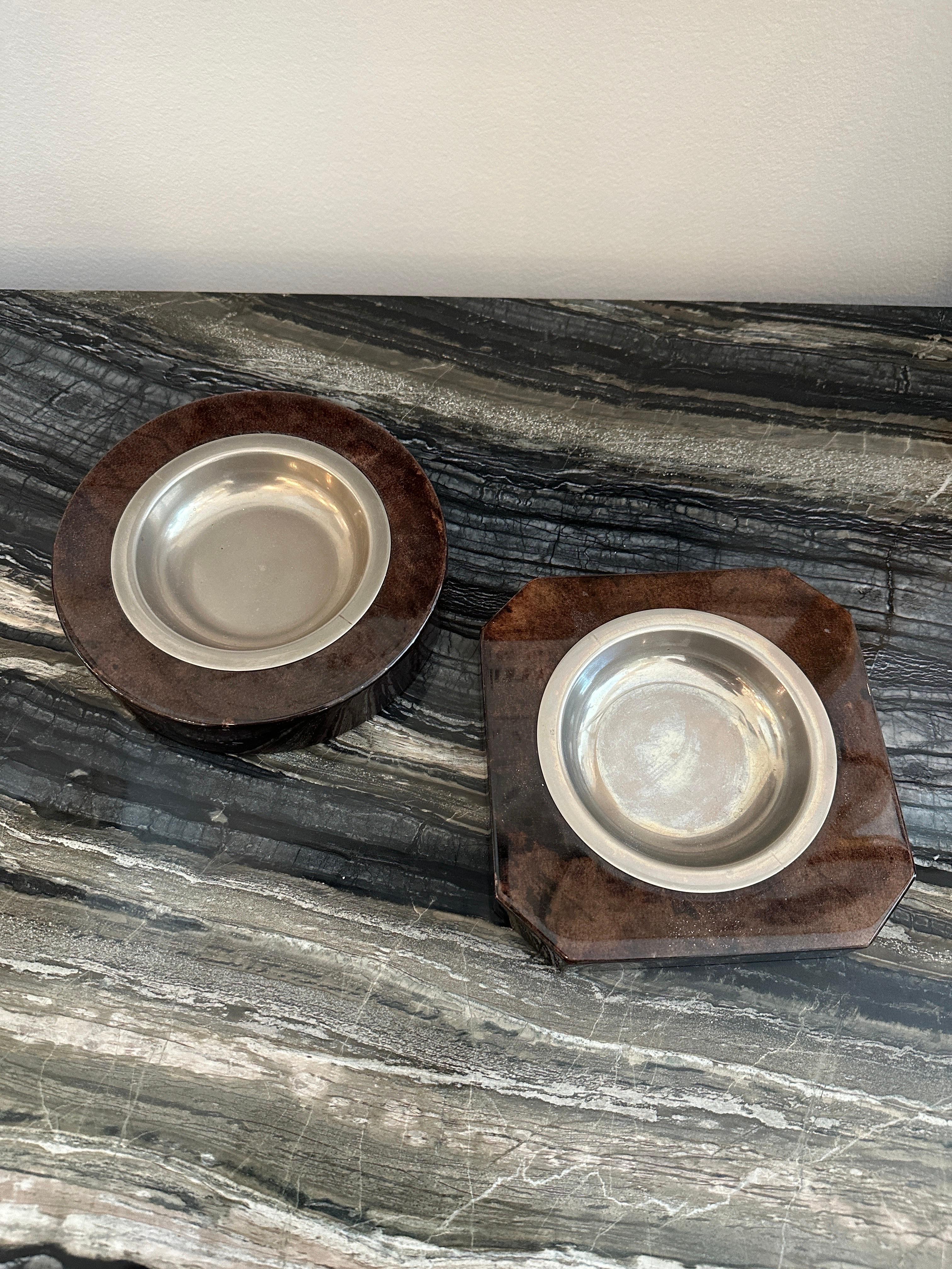This lovely pair of rich brown goatskin clad small bowls in two geometric designs by Aldo Tura, Italy.  THIS ITEM IS LOCATED AND WILL SHIP FROM OUR EAST HAMPTON, NY SHOWROOM.

Square bowl is 6.25 x 6.25, 1 inch tall