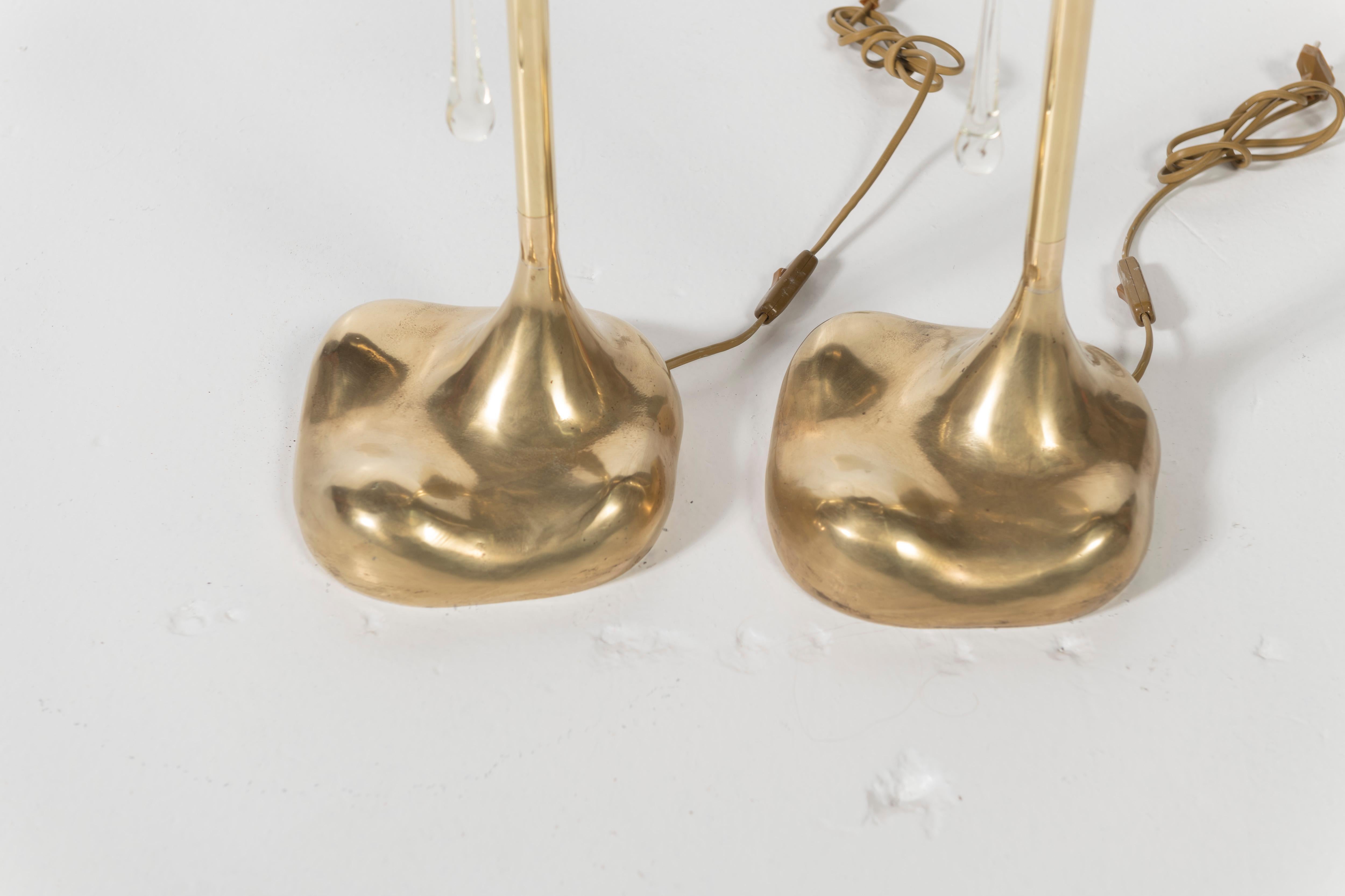 Pair of unusually shaped Italian mid-century tabletop lamps in metal with glass drops. The lights are certain to enlighten any surface and room in which they are placed with great design. Made in Florence, Italy. 

No shades included.