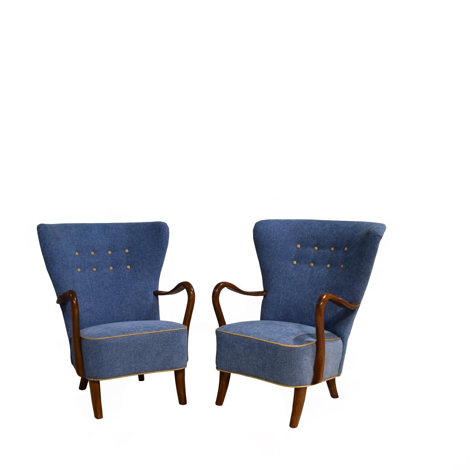 Pair of Danish Modern high-backed lounge chairs by Danish designer, Alfred Christensen, newly recovered in blue fabric, with curved open arms. Extremely comfortable, with buttoned backs and sabre legs in 
walnut from c 1950's.