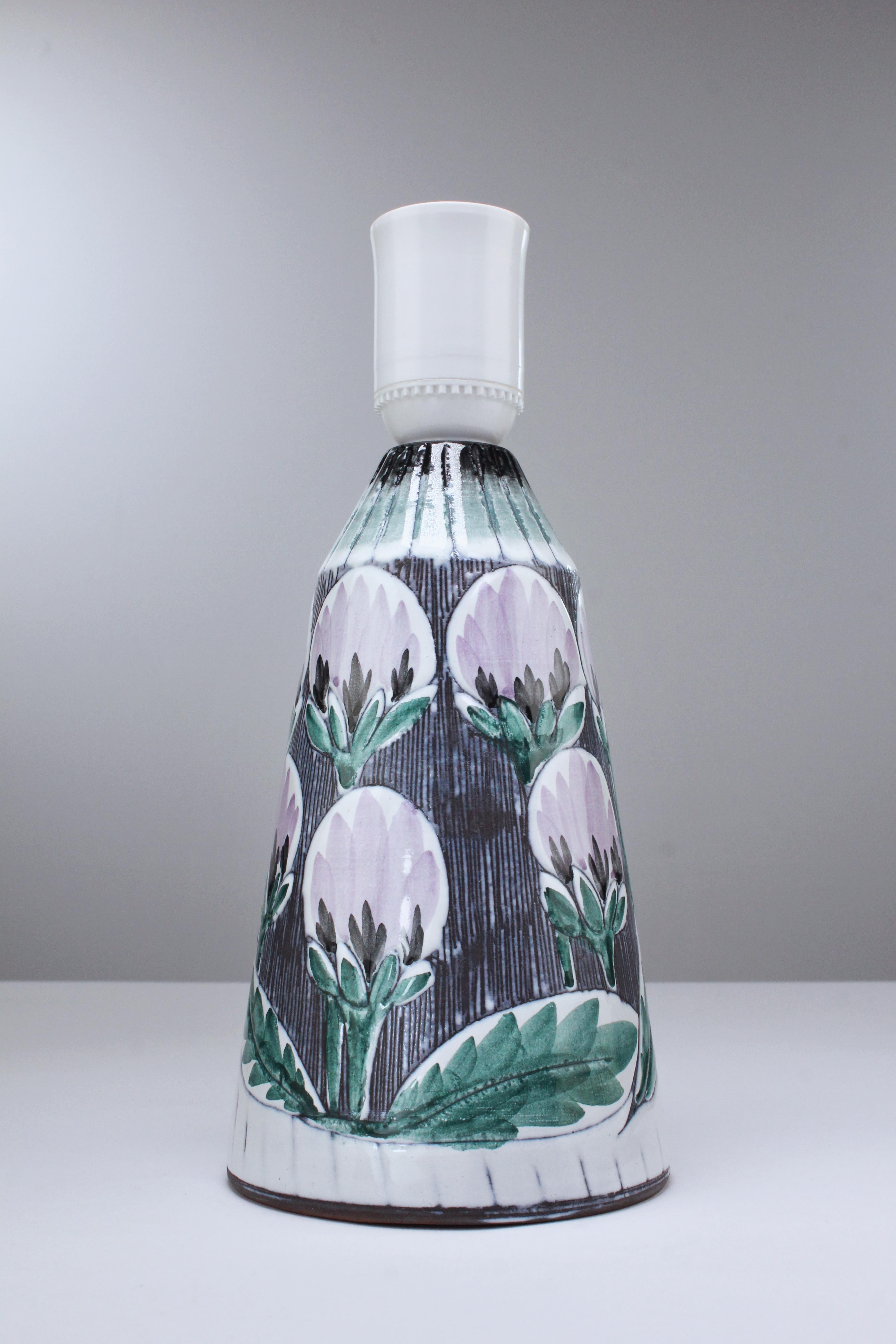 Two handmade Swedish mid century modern ceramic table lamps with white, lilac, green and dark grey glaze creating a pattern of flowers and leaves. Background has been decorated with the sgraffito technique that consists of fine lines carved into the