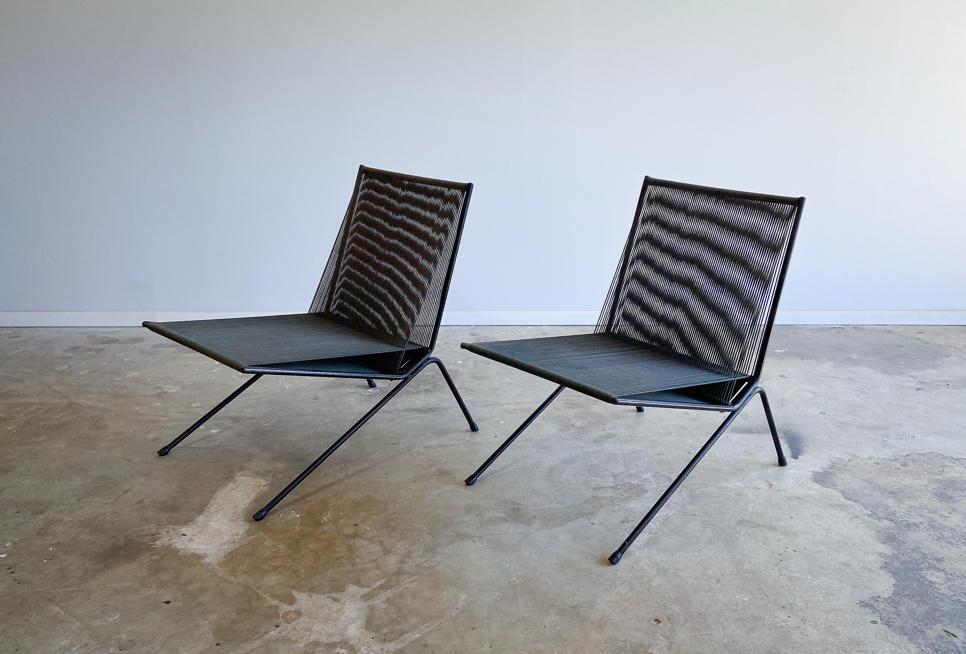 An early pair of American modern iron and string indoor/outdoor lounge chairs designed by Allan Gould for Functional Furniture. Originally introduced in 1952, we believe these to be some of the earliest examples due to the lack of welded cross