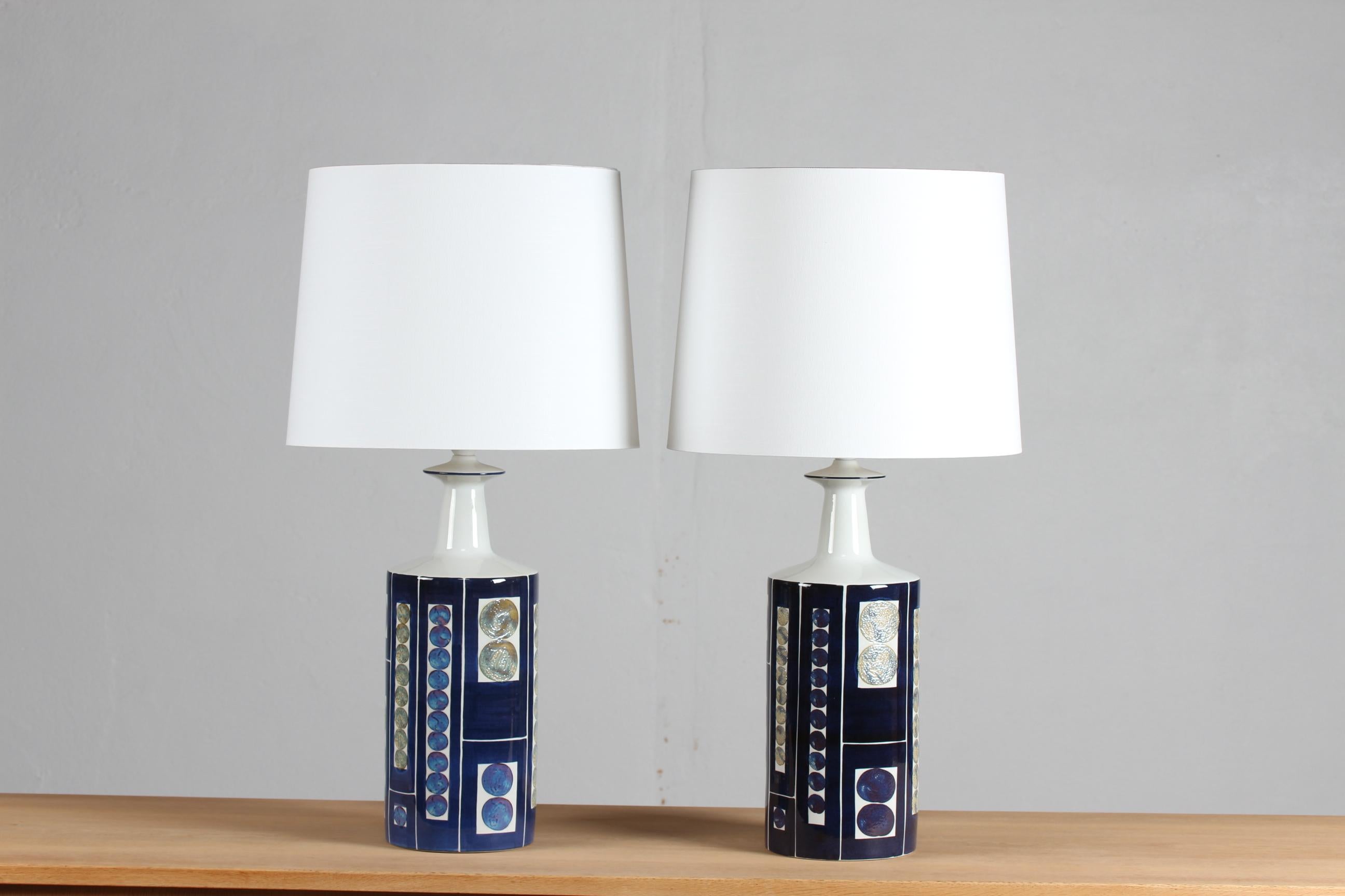 Rare pair of tall table lamps with decor designed by Inge-Lise Koefoed. The lamps were manufactured by Aluminia and Fog & Mørup, Denmark in the 1960s.

The lamps are part of the 