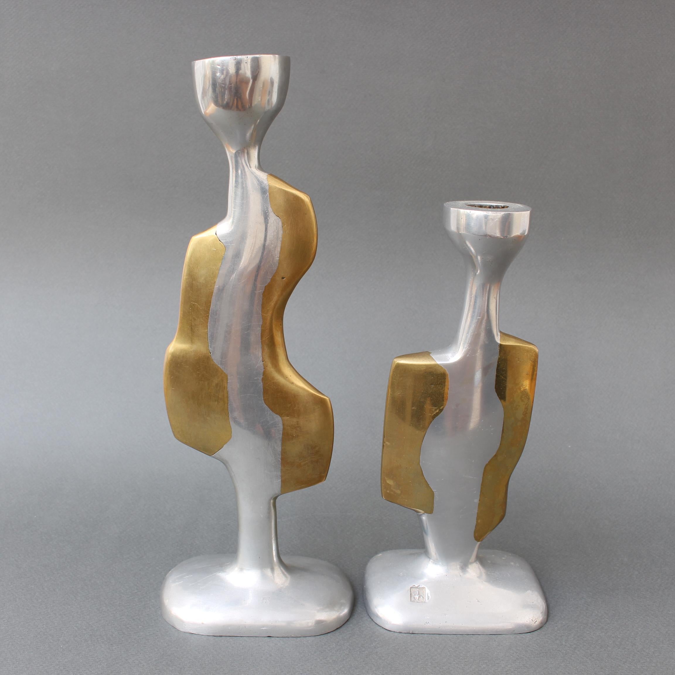 Pair of aluminium and brass brutalist candle stands by David Marshall (circa 1980s). Rather assuming human form, these curvy aluminium and brass candle stands have presence, weight and character. So attractive they can stand on their own in the