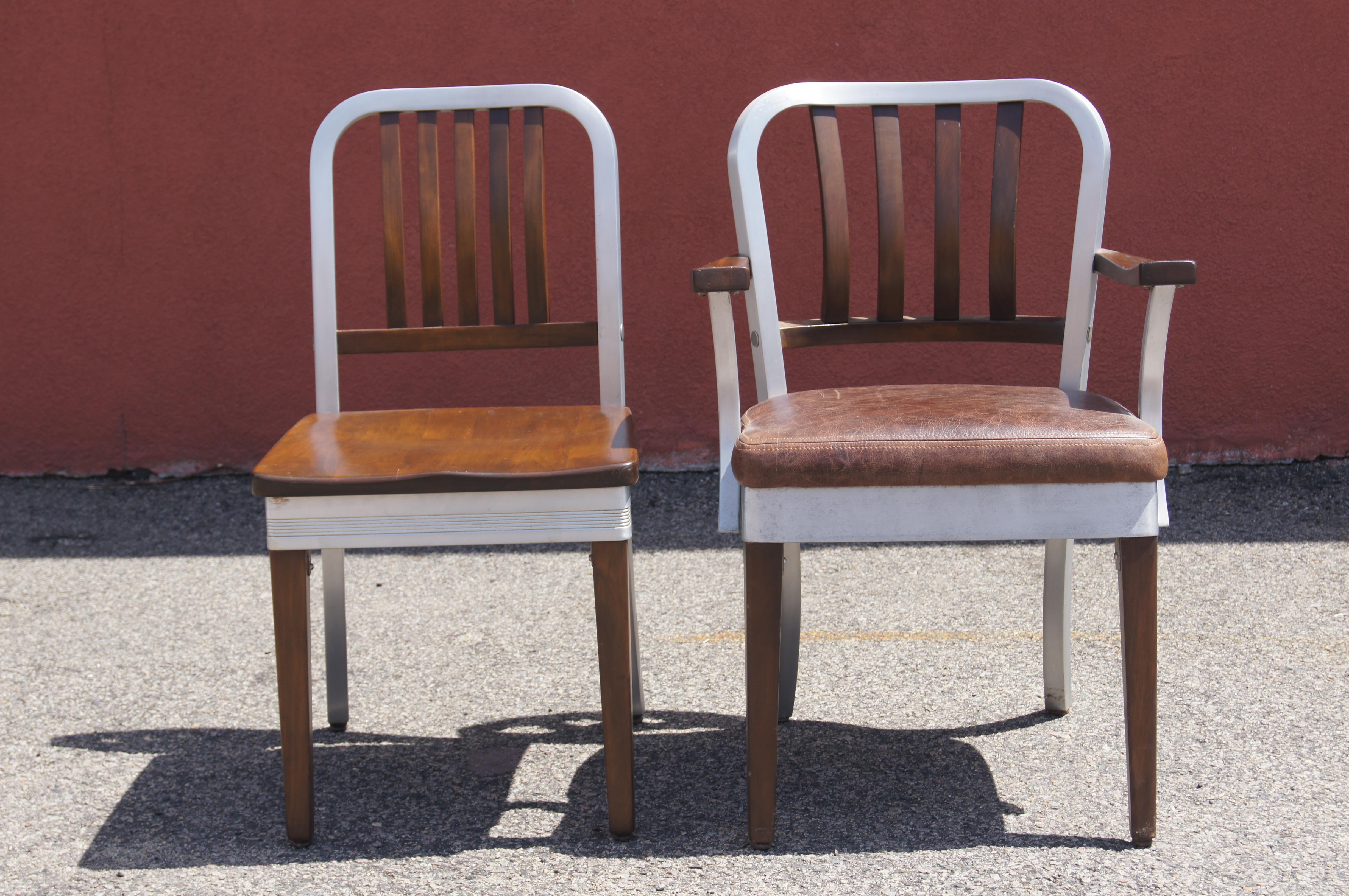 Questa classica sedia industriale e la relativa poltrona sono state prodotte da Shaw Walker alla fine degli anni Quaranta. Entrambe presentano telai curvi in alluminio spazzolato con schienali a doghe e gambe anteriori in acero massiccio. La sedia