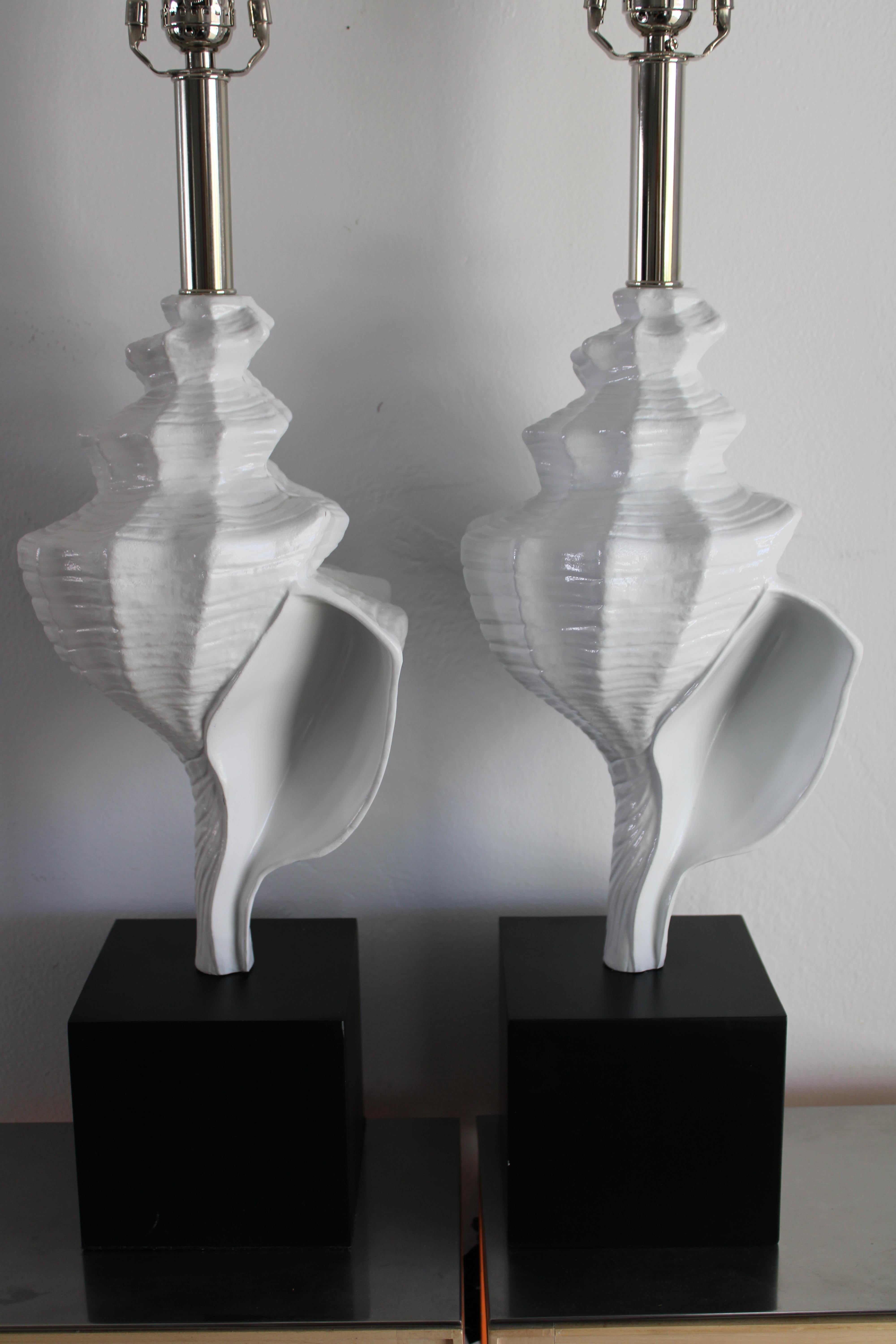 Pair of aluminum seashell lamps attributed to the Laurel Lamp Company, Newark, New Jersey. The seashell is 13.25” high. Total height from the base to the bottom of socket is 22.5”. Base is 5.5” wide, 5.5” deep and 5” high. Lamps have been