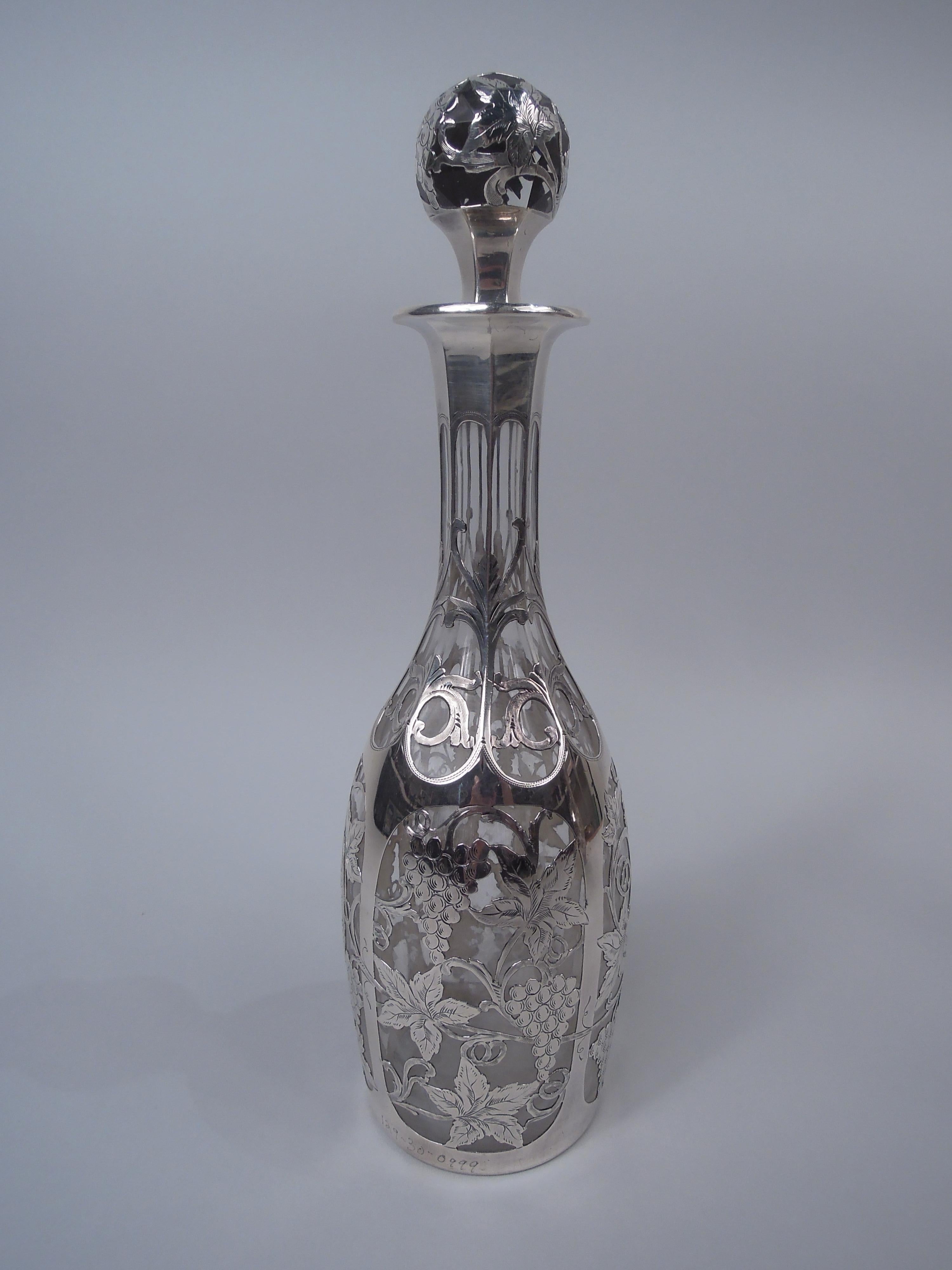 Paar Jugendstil-Glaskaraffen mit graviertem Silberaufsatz, um 1900. Jede: Eiförmige Schale, facettierter Hals und umgedrehter Rand mit Silberkragen; facettierter Kugelstopfen. Overlay in Form einer fruchttragenden Weinrebe mit übergroßen Blättern,