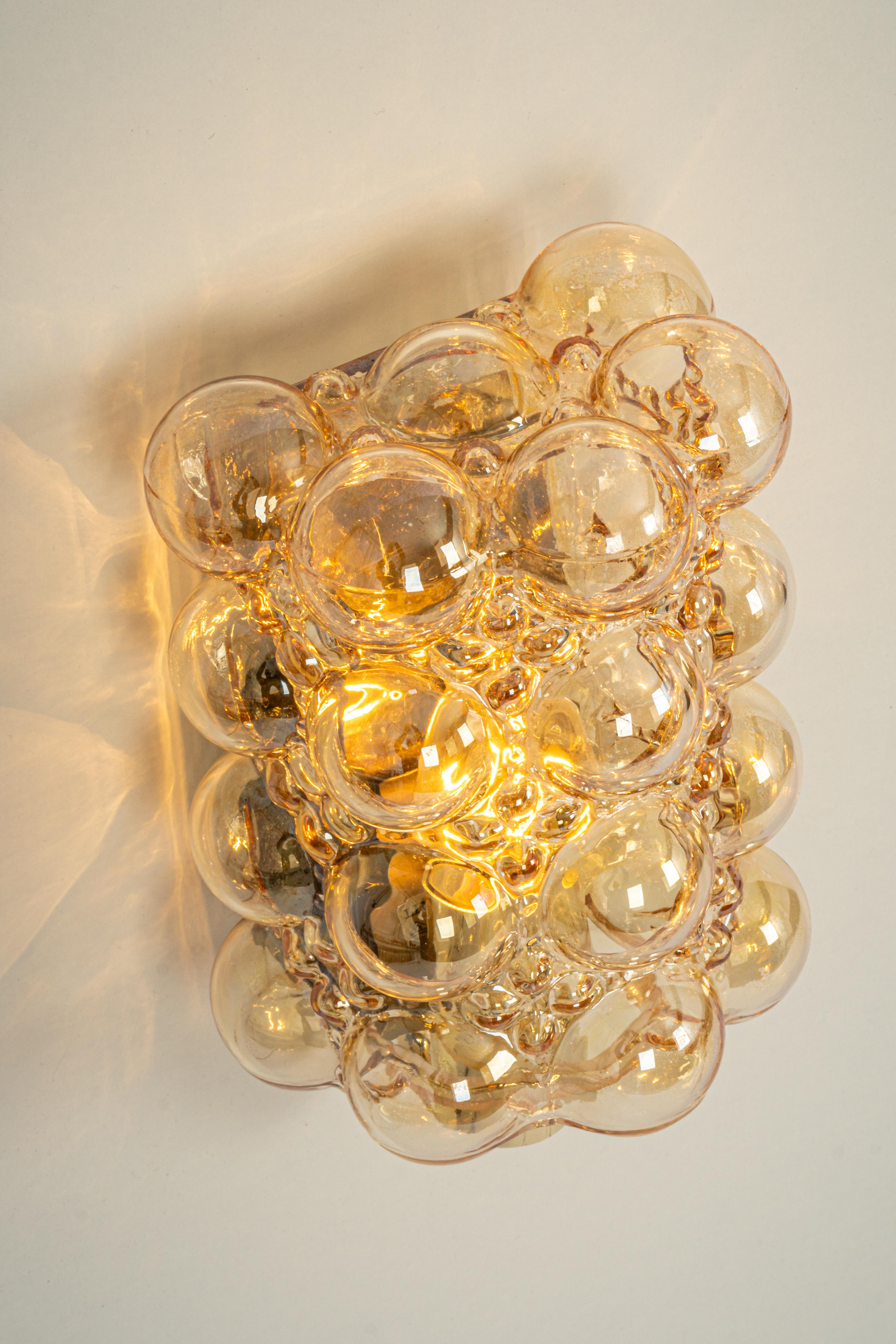 Wonderful Large pair of golden wall lights, from Limburg Glashütte, Germany, circa 1960-1970. Smoked bubble glasses on a golden brass base.

For each sconce:

Heavy quality and in very good condition. Cleaned, well-wired and ready to use.
Each wall