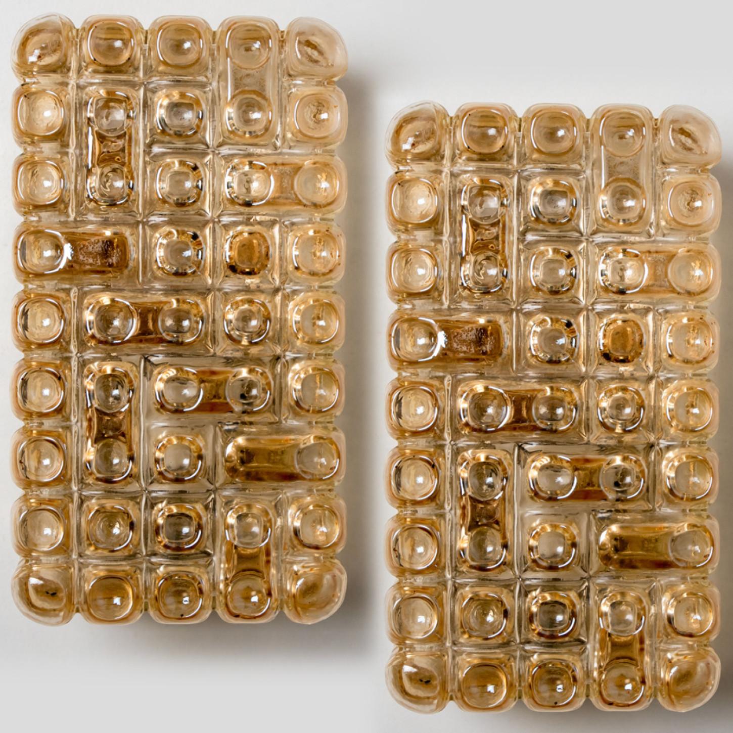 Amber colored bubble glass wall lights designed in the style of Helena Tynell around 1960-1970 in Europe, Germany. The rich textured bubbled glass gives a wonderful glow. The rectangle glass is mounted on a chrome back plate.

Please notice the