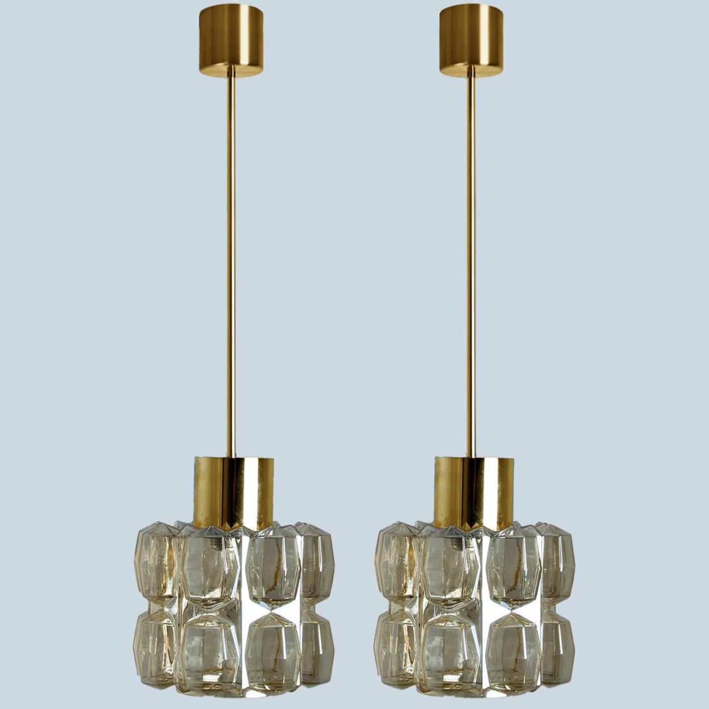 Pair of beautiful bubble glass and gold chandelier or pendant light designed by Helena Tynell for Glashütte Limburg. A design Classic, the amber colored/toned hand blown glass gives a wonderful warm glow.

Helena Tynell is a finish glass and