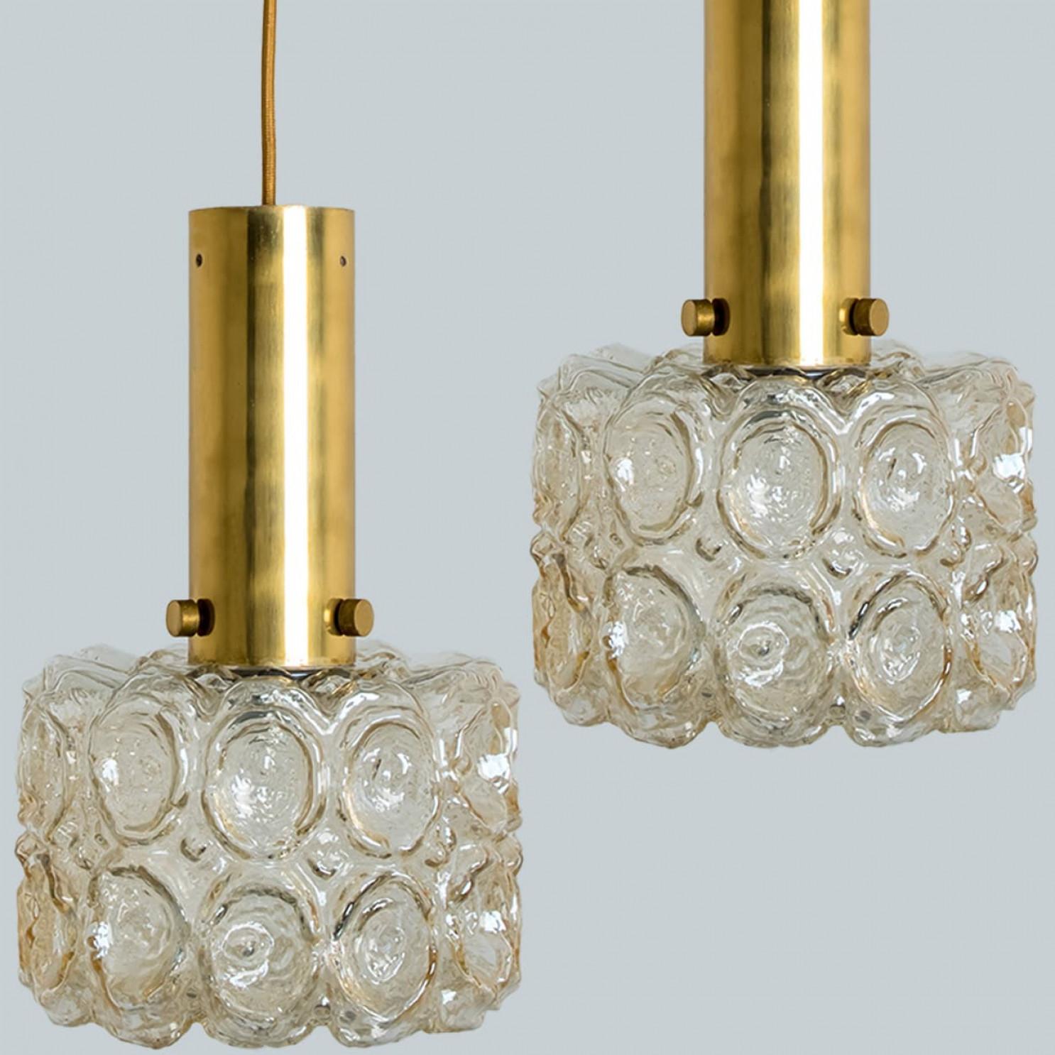 Pareja de preciosas lámparas de araña o colgantes de cristal burbuja y oro diseñadas al estilo de Helena Tynell. Un clásico del diseño, el vidrio soplado a mano de color ámbar/tono proporciona un maravilloso resplandor cálido.

Helena Tynell es