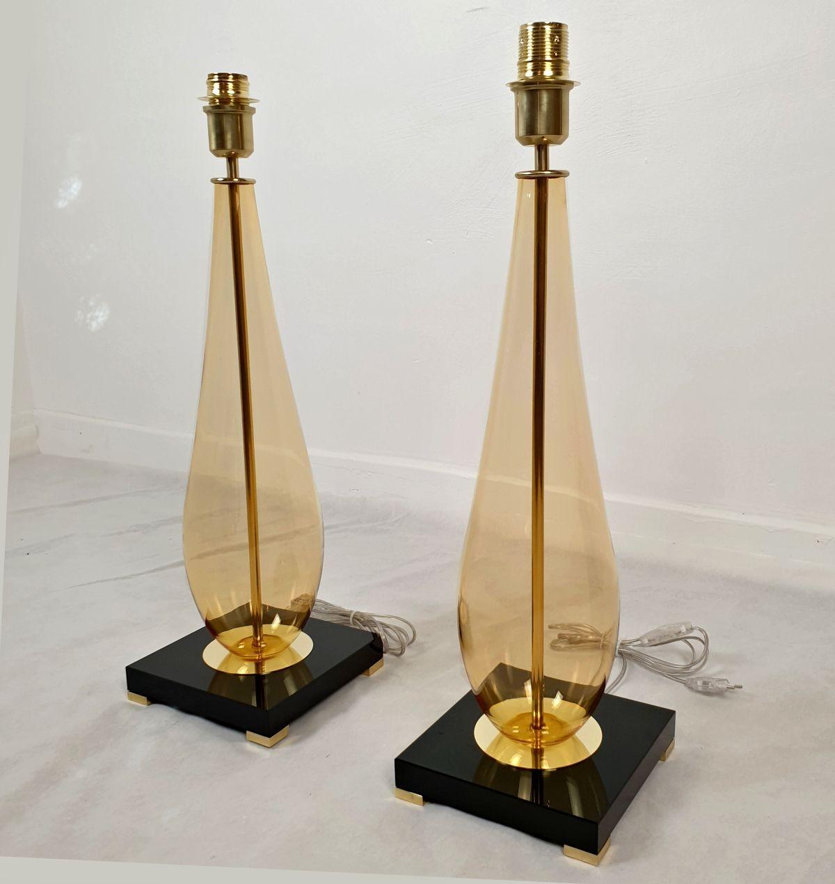 Pair of amber Murano glass table lamps Mazzega style, Italy 1990s.
Set of four lamps, two pairs of lamps available. Sold and priced in pairs.
The Mid-Century Modern table lamps are made of a square black Murano glass base and an amber center Murano