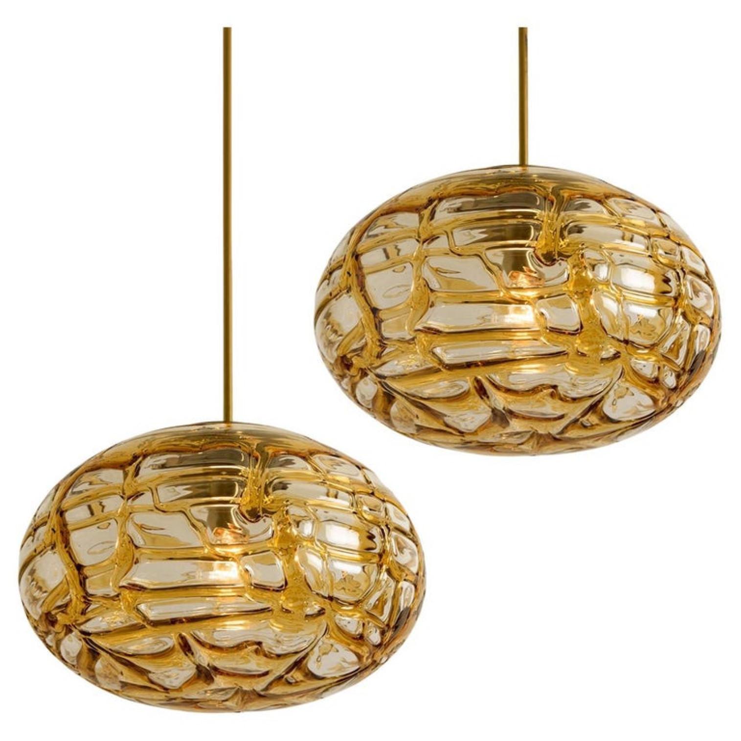 Doria ceiling light with an oval Murano amber glass and brass glass ball. Heavy quality, gives a wonderful light effect when it is on. Amber glass, brass. Period: 1970
Dimensions: H 7.5