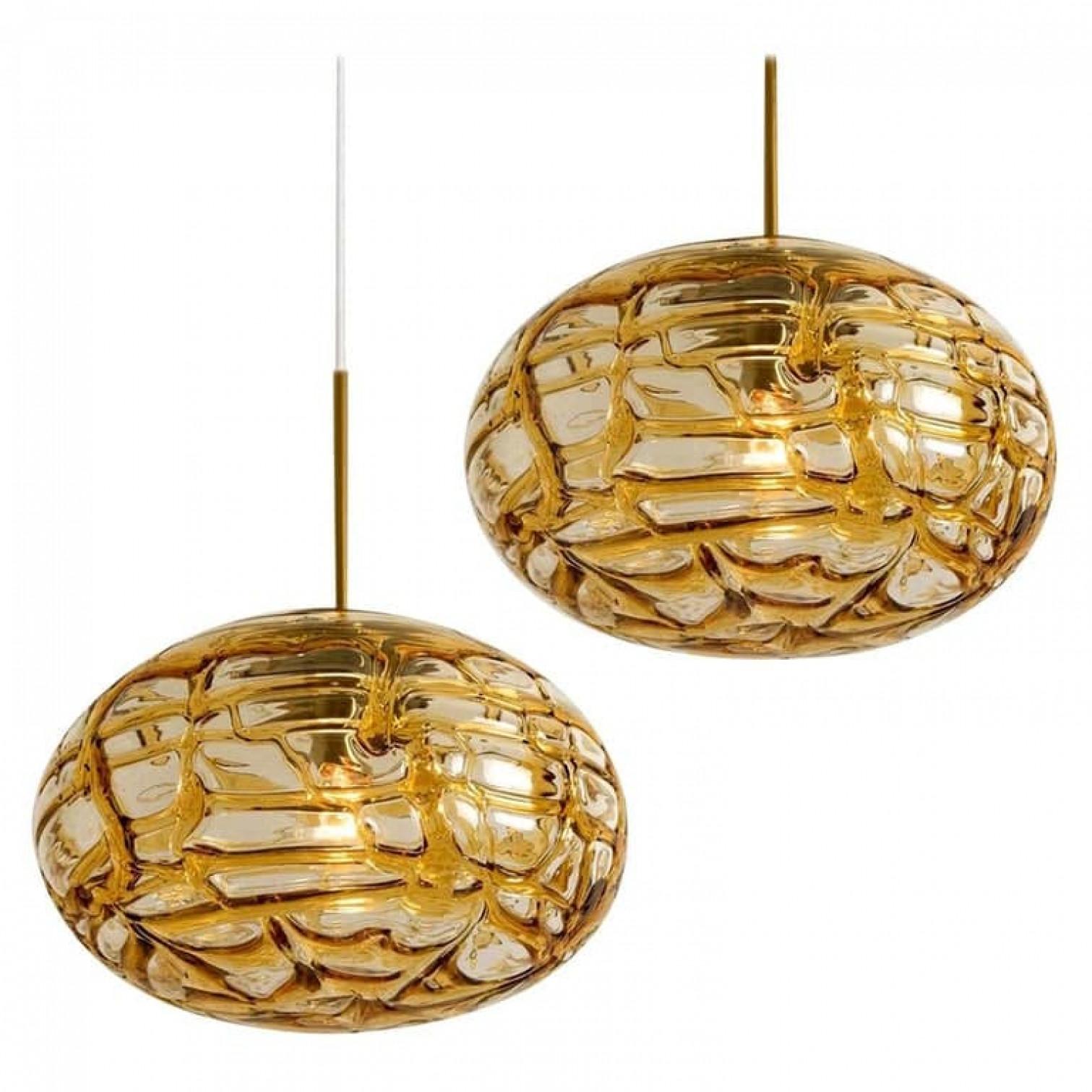 Doria ceiling light with an oval Murano amber glass and brass glass ball. Heavy quality, gives a wonderful light effect when it is on. Amber glass, brass. Period: 1970
Dimensions: H 7.5
