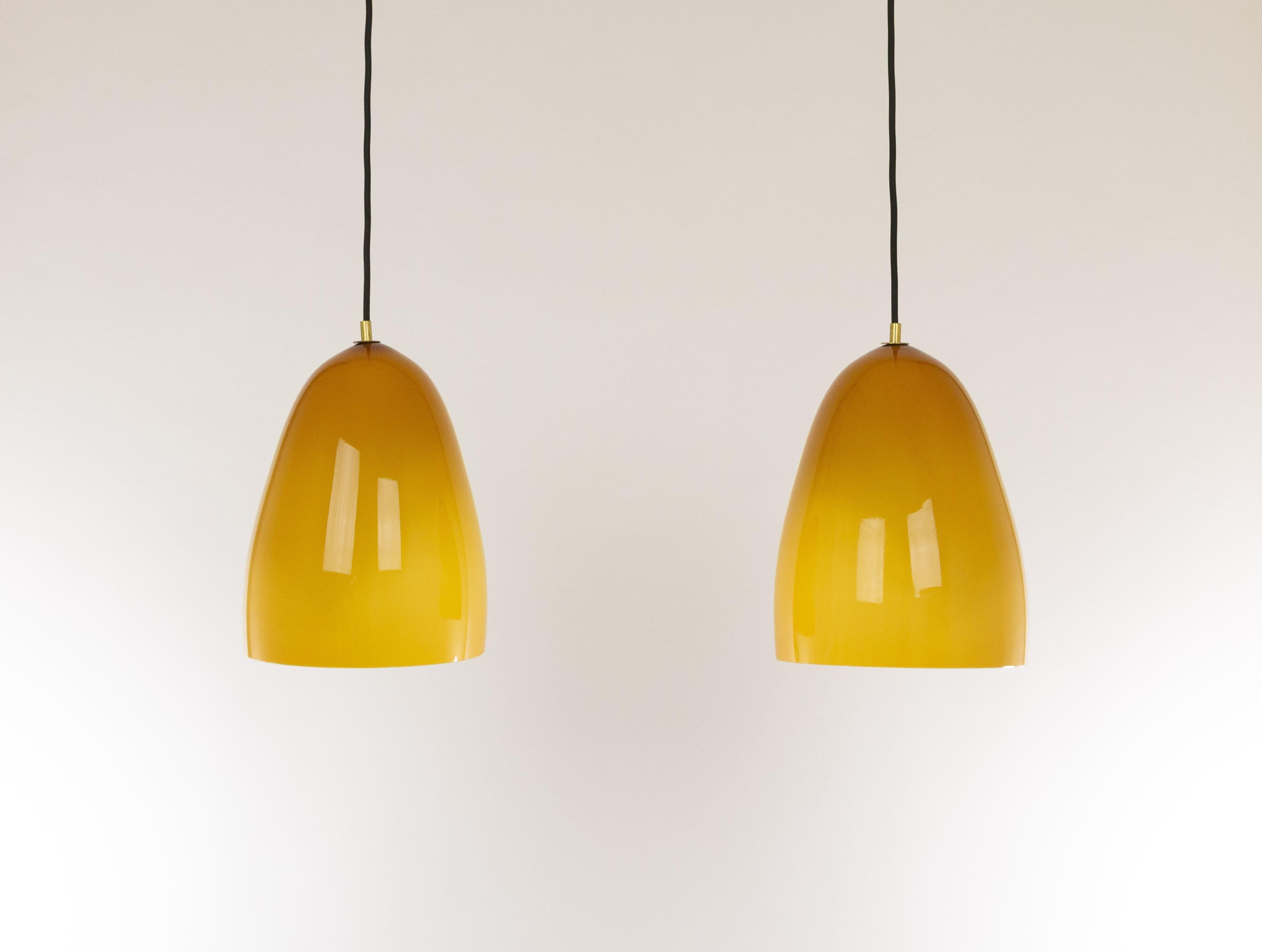 Hand-blown glass amber Model 011.8 pendants designed by Massimo Vignelli at the start of his impressive career in design and produced by Murano glass specialist Venini.