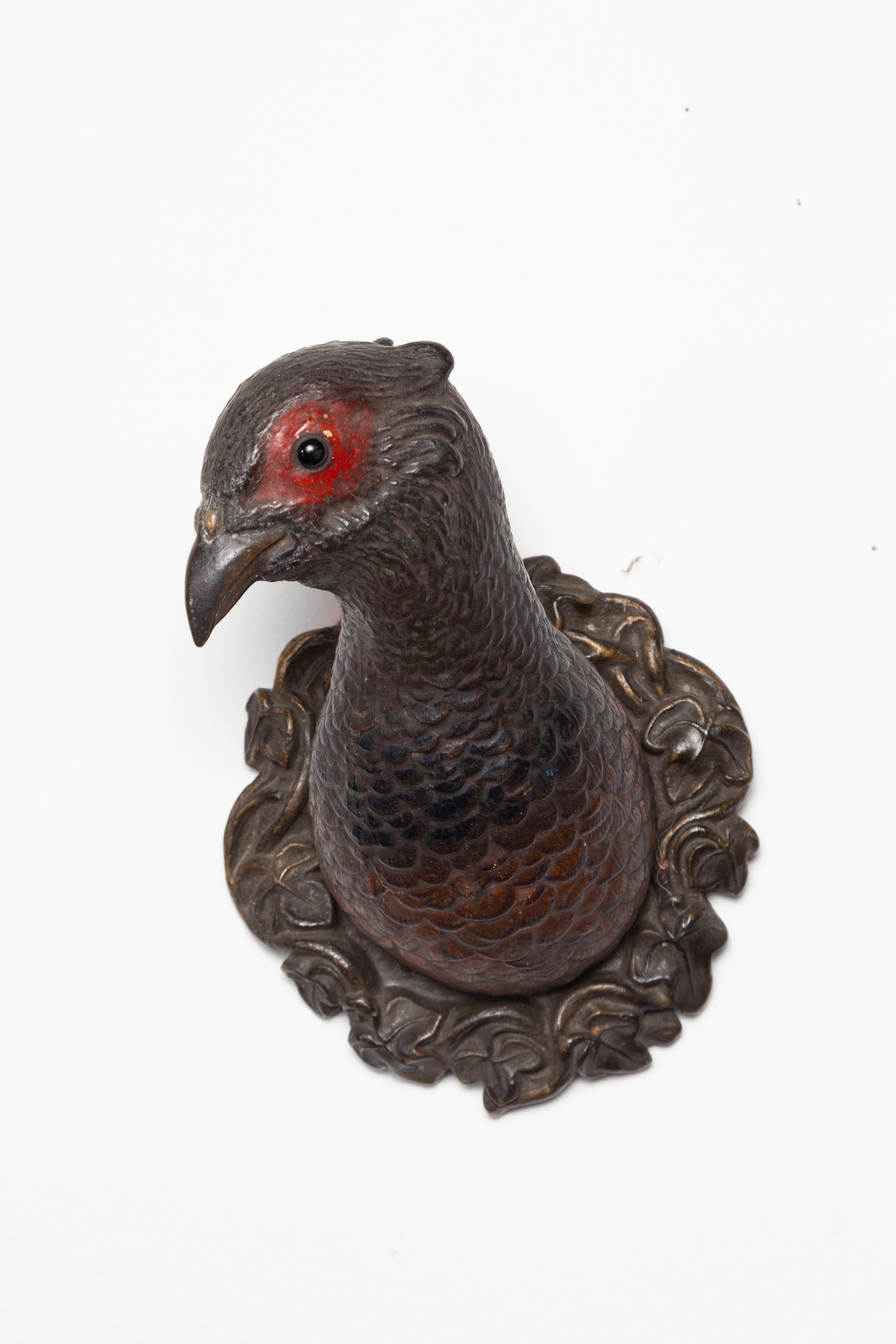 A pair of American terracotta turkey wall sculptures from the mid-20th century, with glass eyes and red accents. Made in the USA during the second quarter of the 20th century, each of this pair of wall sculptures features a turkey with glass eyes