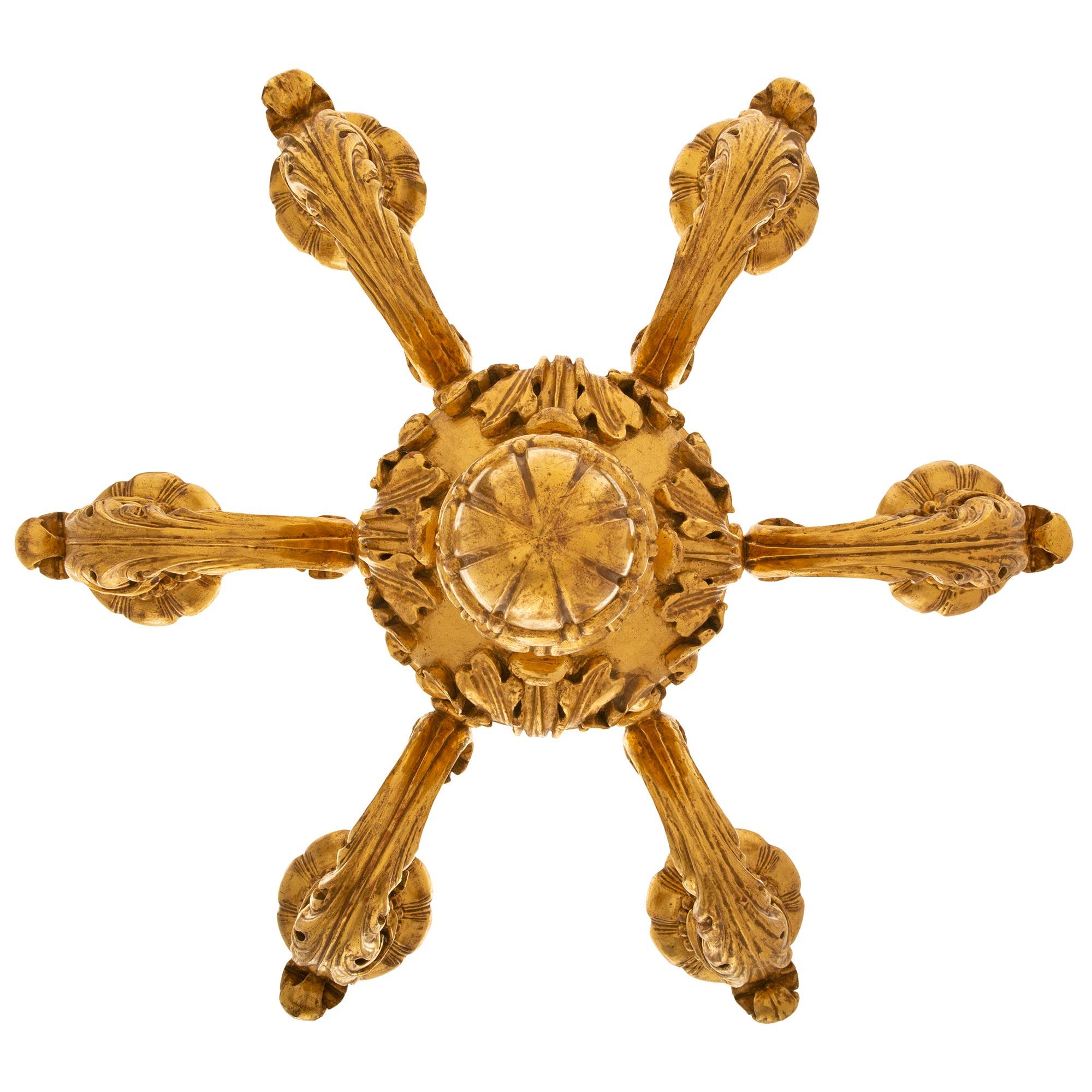 Paire de lustres américains en bois doré de style Louis XV du 19e siècle, estampillés Caldwell. Chaque lustre d'inspiration italienne à six bras est estampillé 'C' pour Edward F. Caldwell, et est centré par un élégant fleuron inférieur en roseau