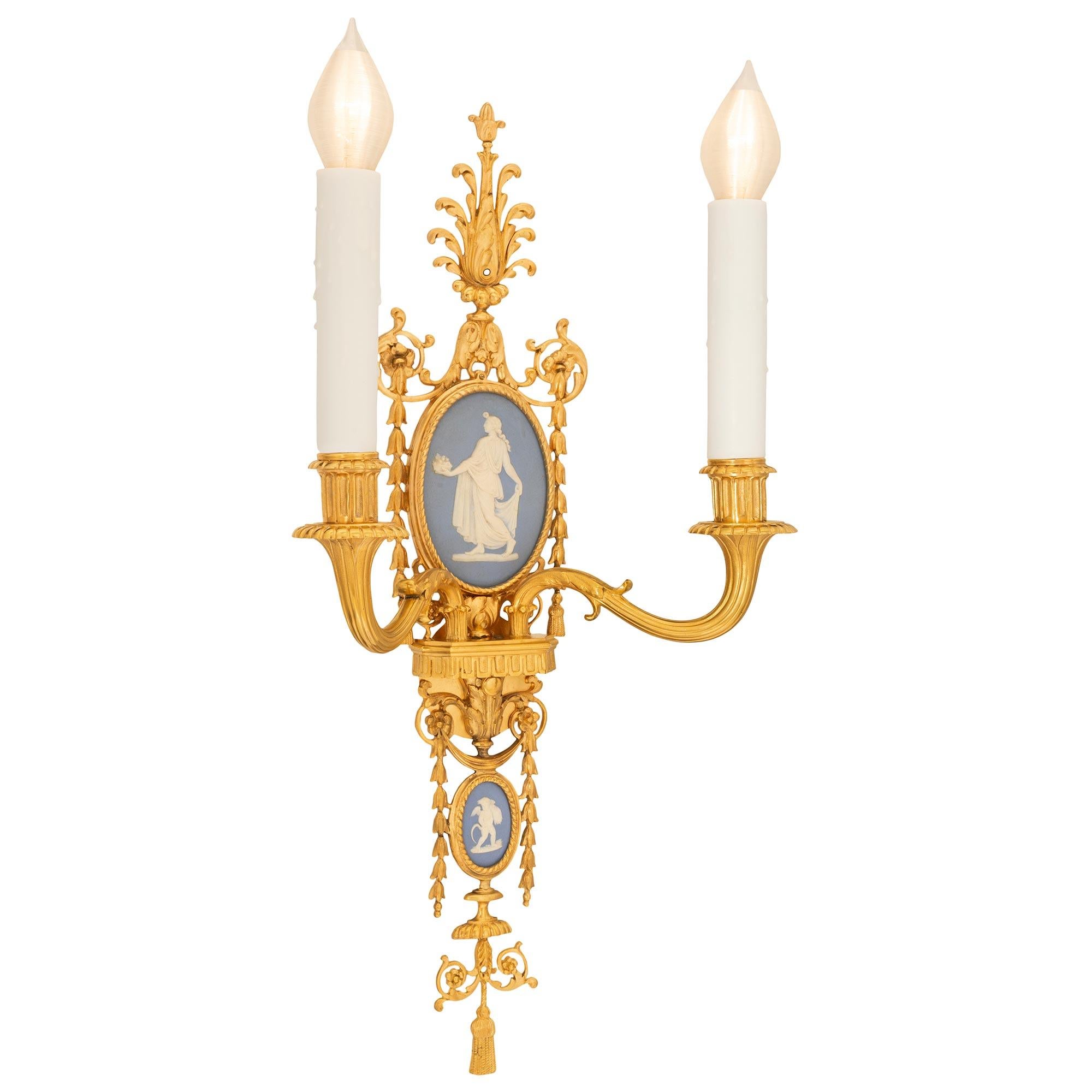 A remarkable and extremely decorative pair of American 19th century Louis XVI st. ormolu and Wedgwood sconces signed Caldwell. Each two arm sconce is centered by a charming tassel and beautiful scrolled Rinceau and reeded elements below fine fitted
