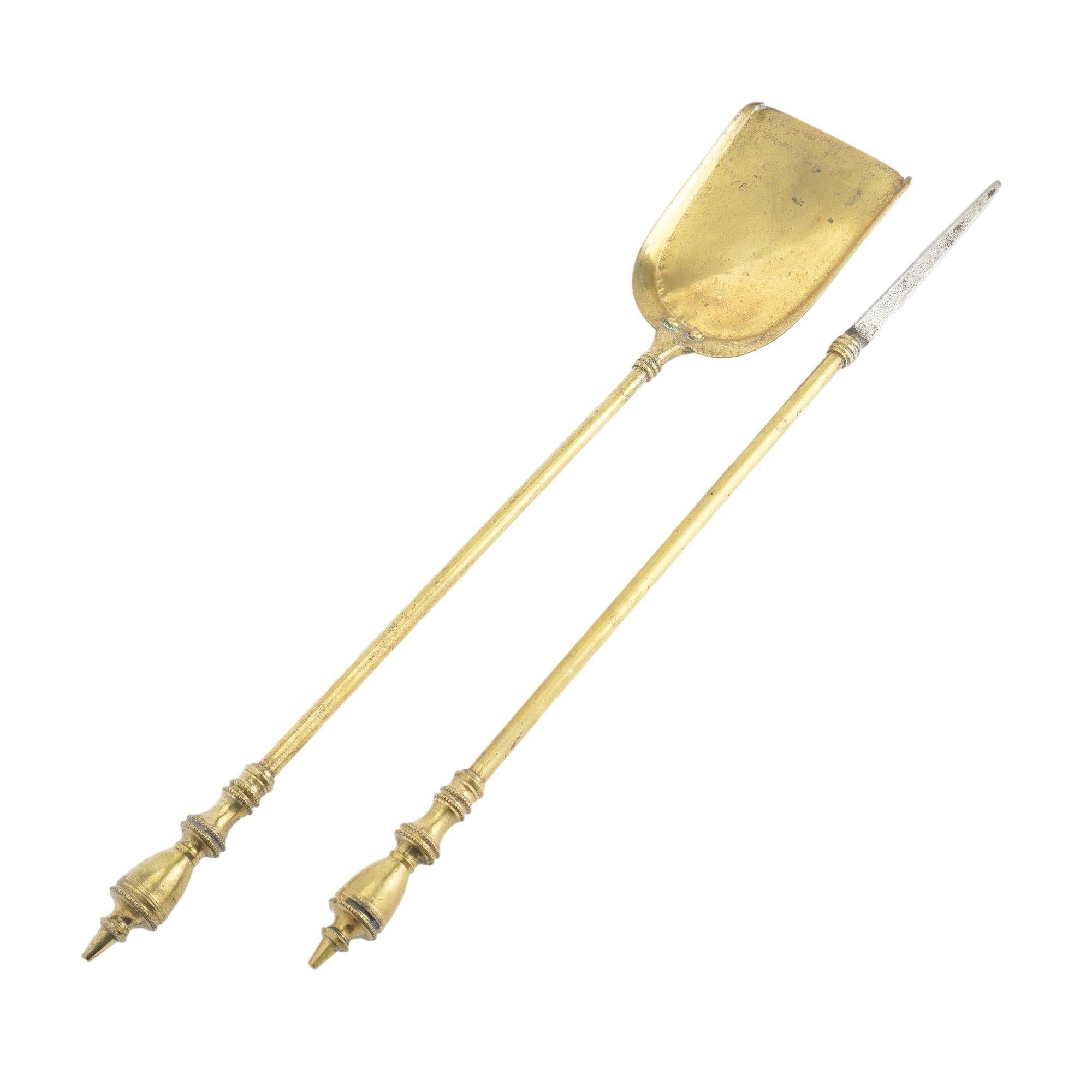 Pair of Academic Revival brass fire tools consisting of a shovel and poker with urn finial. The poker has an iron tip.
American, circa 1950.