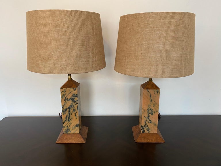 An original pair of rare 1920 American Art Deco table lamps composed marble columns and walnut bases with aged brass/bronze hardware. Rewired. Body height to the top of the wood is 12.5”.