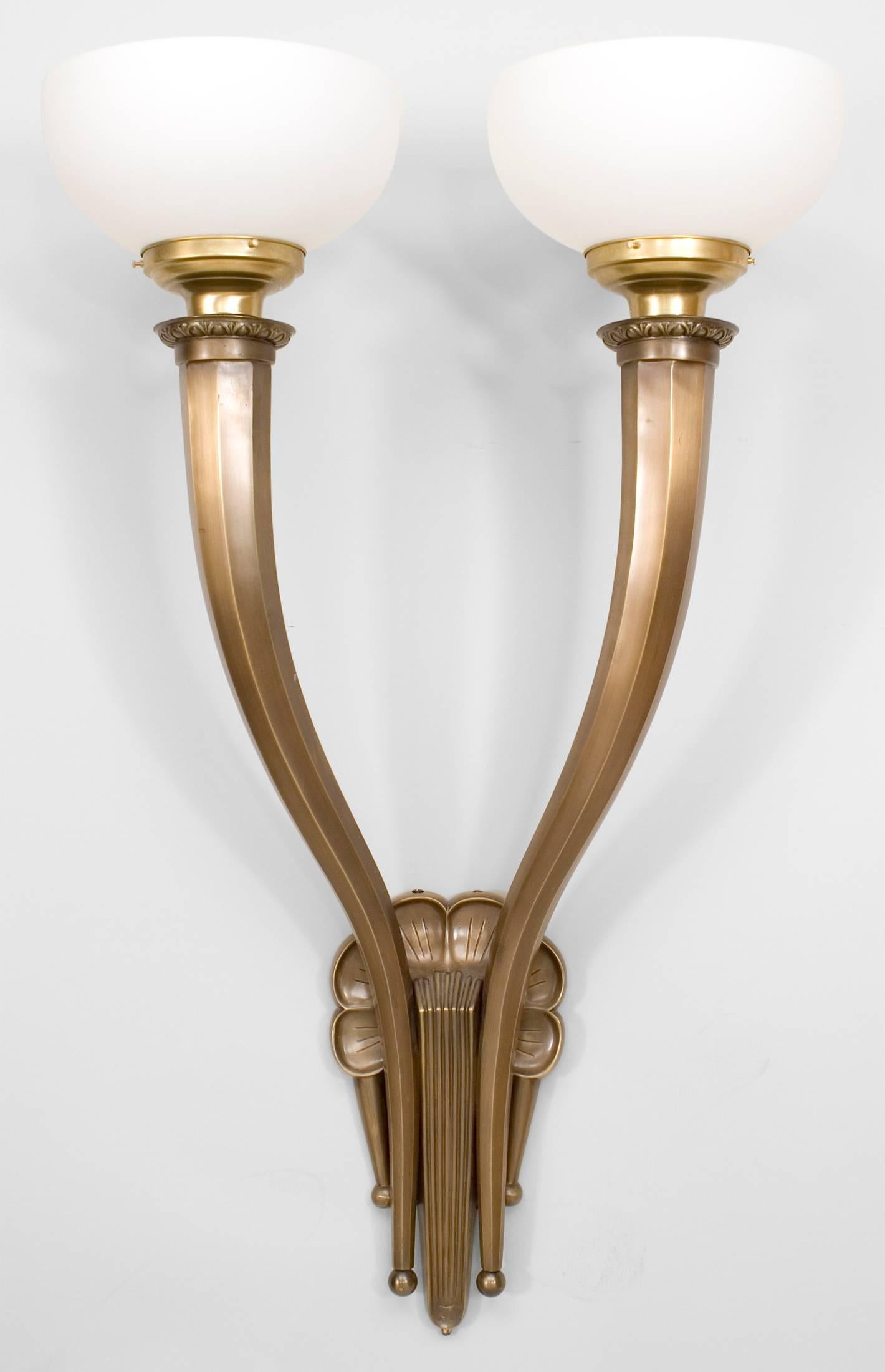 Pair of American Art Deco monumental bronze wall sconces with two eight-sided arms, fluted and scalloped backplates, and frosted glass shades. (PRICED AS Pair)
