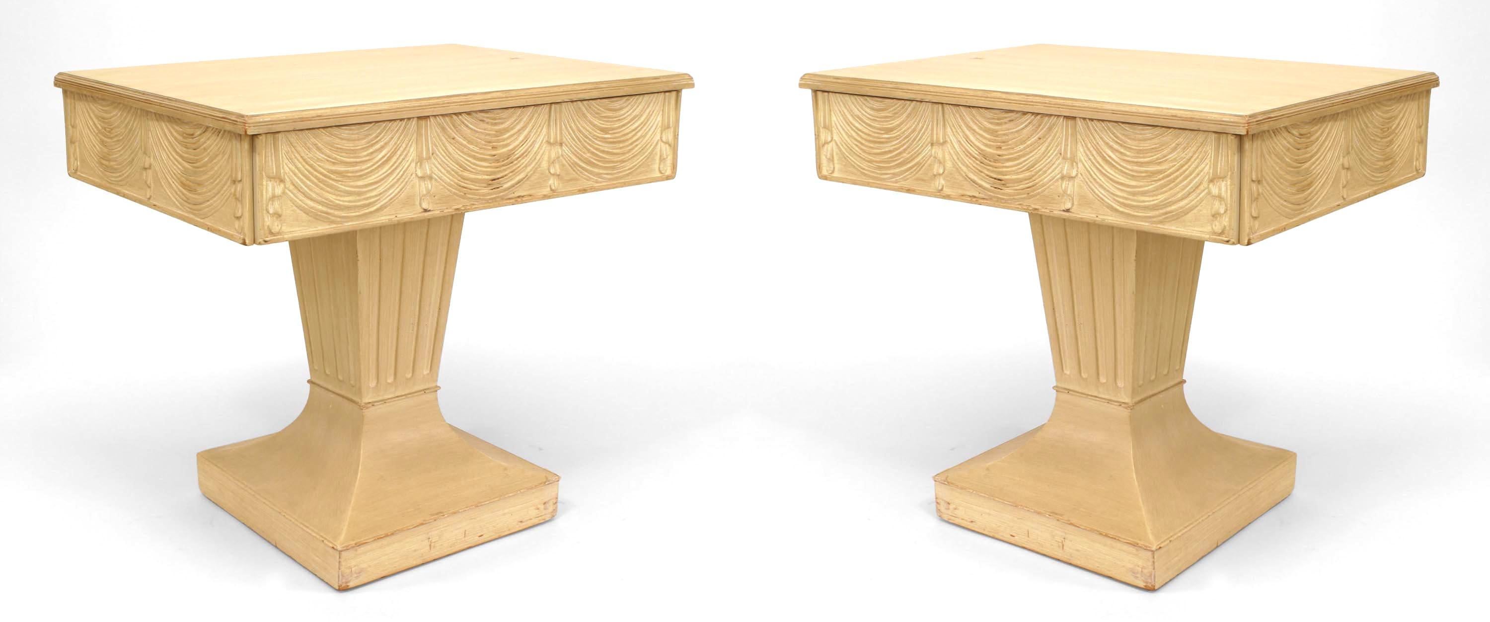 Pair of American Art Moderne bleached end tables with swag carved design on 3 sides and a drawer supported on a square fluted pedestal base. (Attributed to GROSFELD HOUSE) (PRICED AS Pair)
