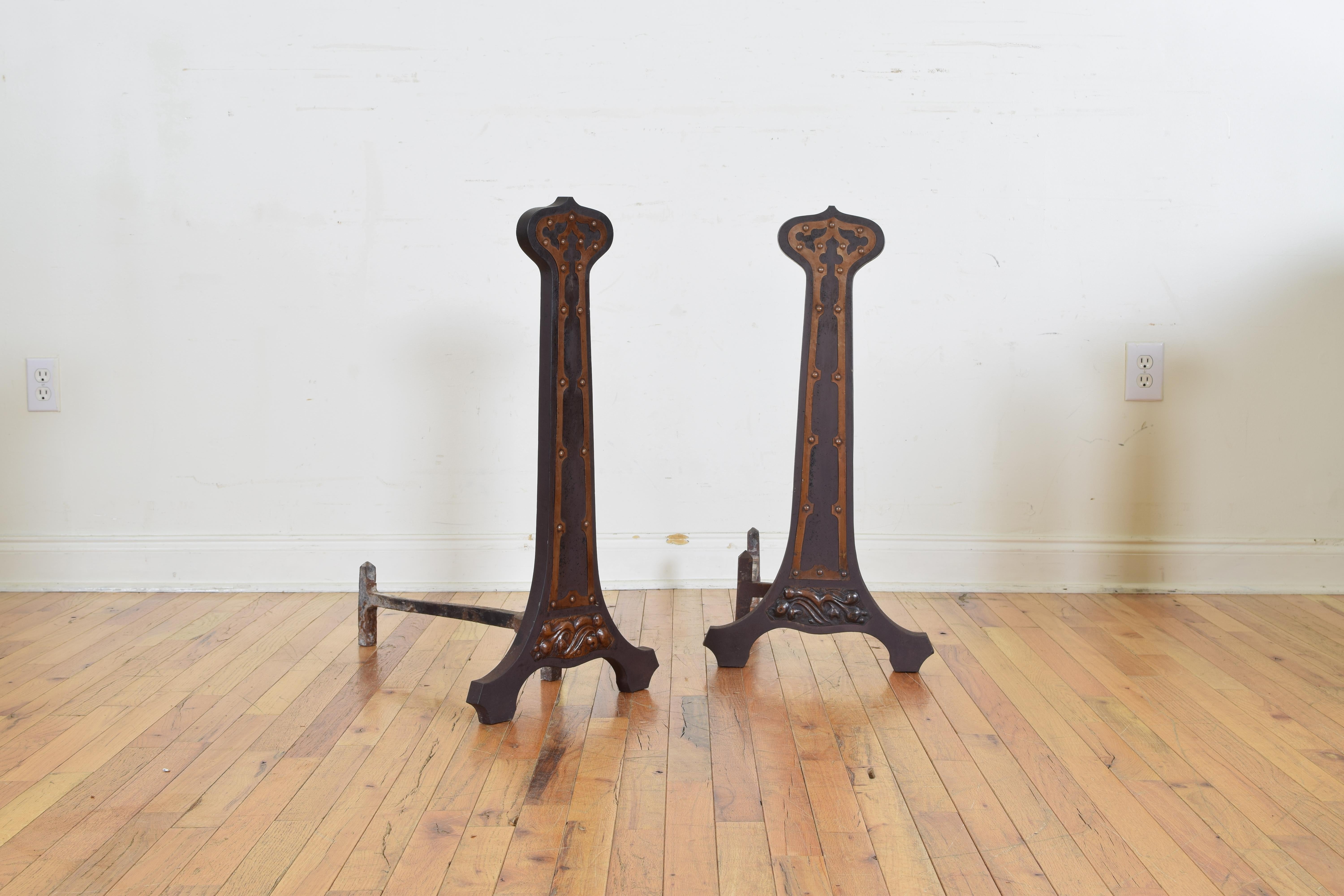 Pair of iron and copper andirons of larger scale and having spade shaped tops and splayed bracket feet, the fronts decorated with copper detailing and rivets/nailheads.