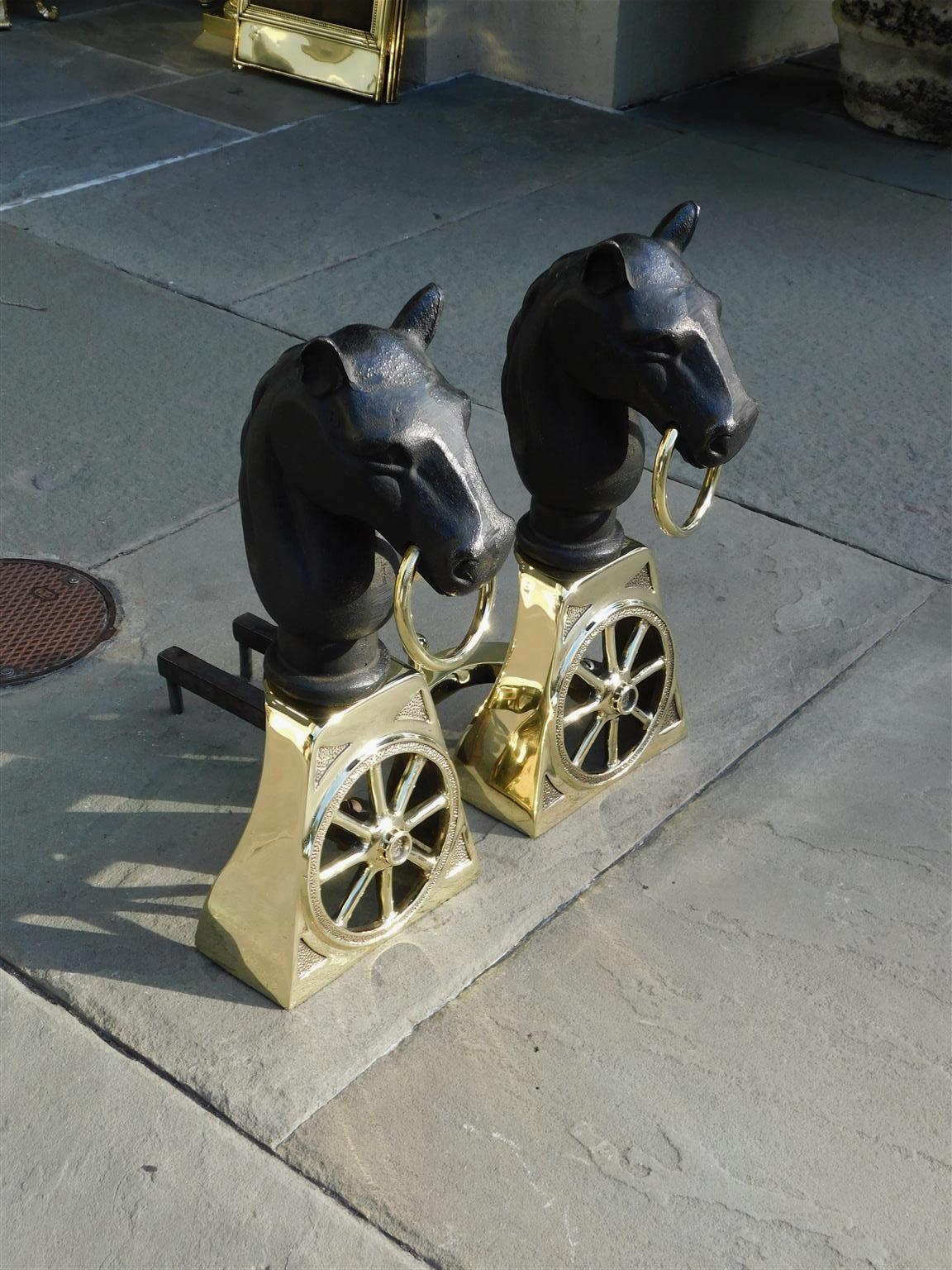 Pair of American brass and cast iron horse head wagon wheel andirons with flanking ball finial log stops, mid 19th century.