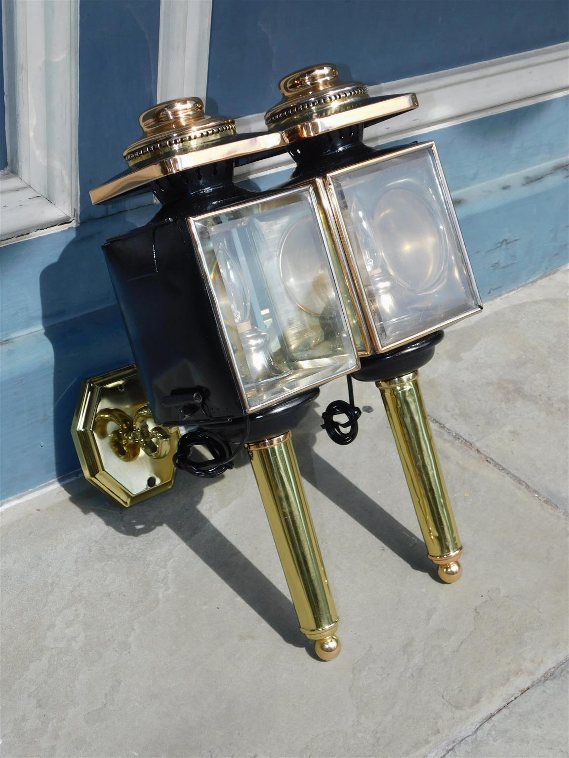 Pair of American brass and copper coach lanterns with the original beveled glass and foliage scrolled mounting brackets. Warner and Co. Cherry ST. Philadelphia. Pair have been electrified and lacquered for exterior exposure. Early 19th Century.