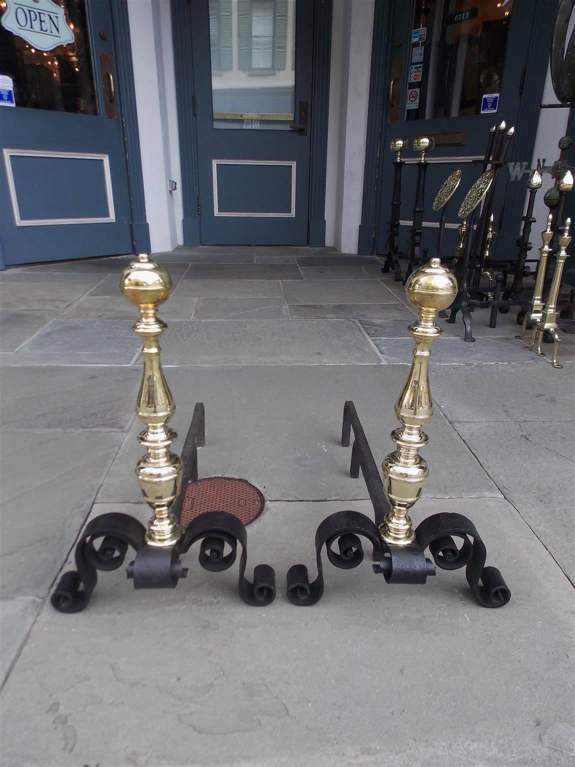 Pair of American brass and wrought iron andirons with ball ringed finials, turned bulbous centered columns, spit hooks, and terminating on scrolled decorative legs, Mid-19th century.