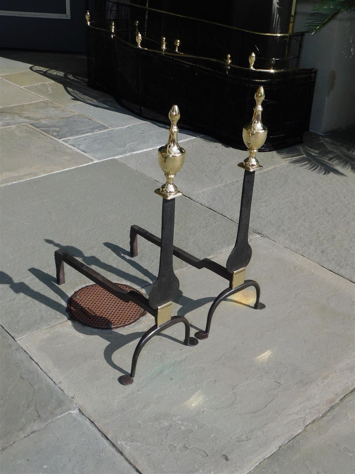 Pair of American brass and wrought iron flanking urn finial knife blade andirons with scrolled legs and penny feet. Early 19th Century